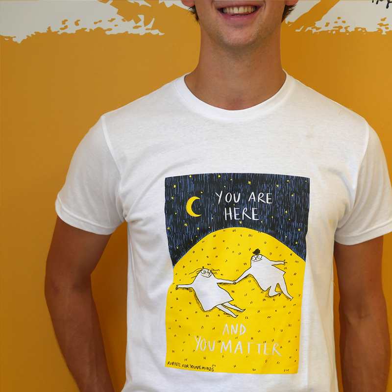 A close up of a man smiling wearing our Rubyetc bespoke 'You are here and you matter' graphic #HelloYellow T-shirt