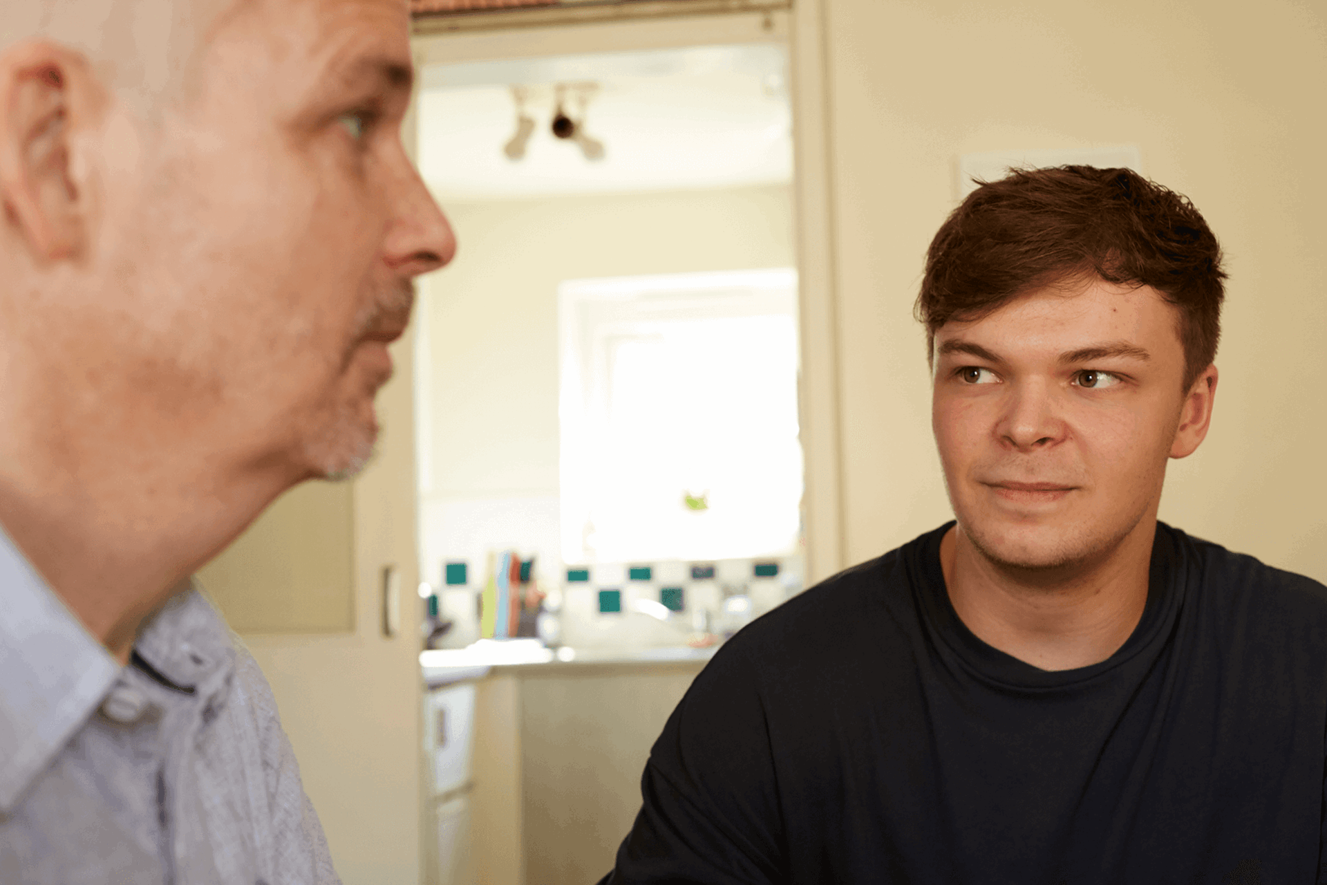 A father and son at home together having a conversation