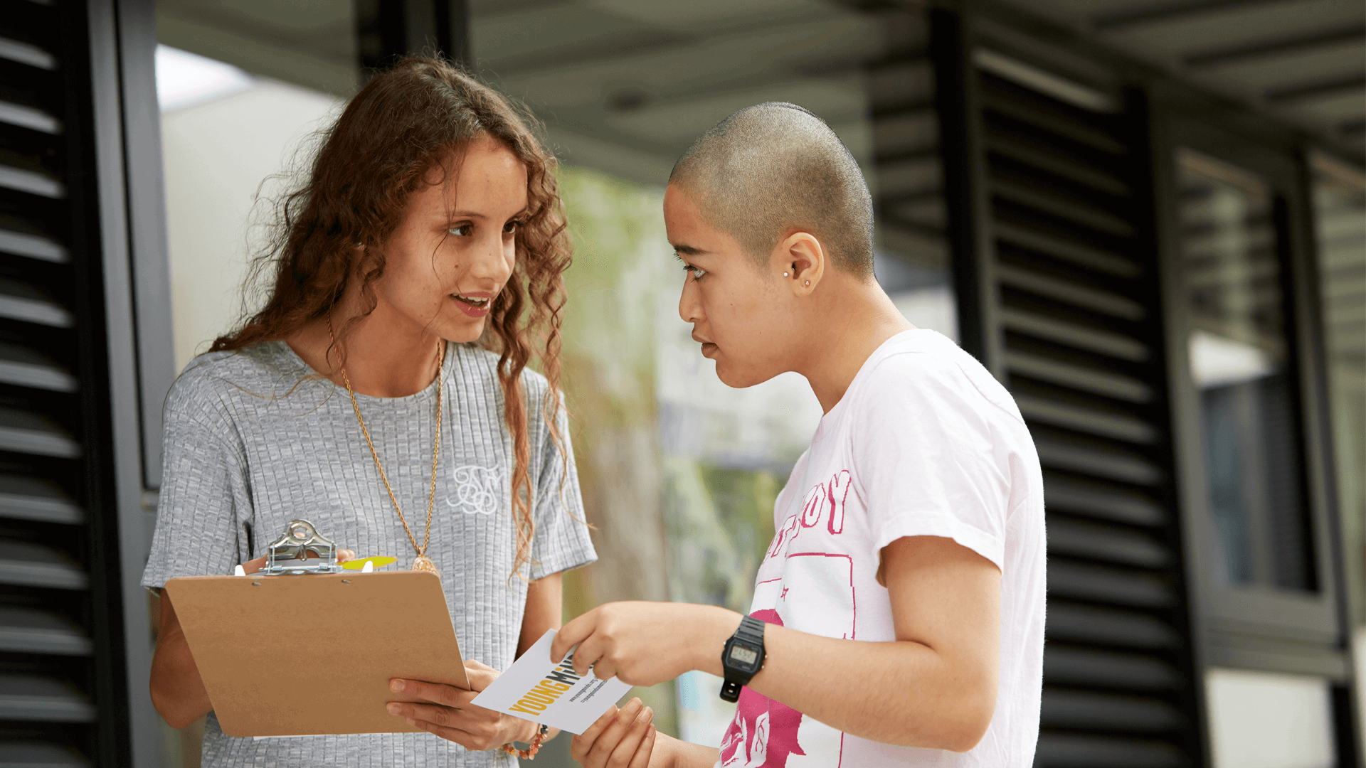 YoungMinds volunteer giving out YoungMinds leaflet to a student in campus