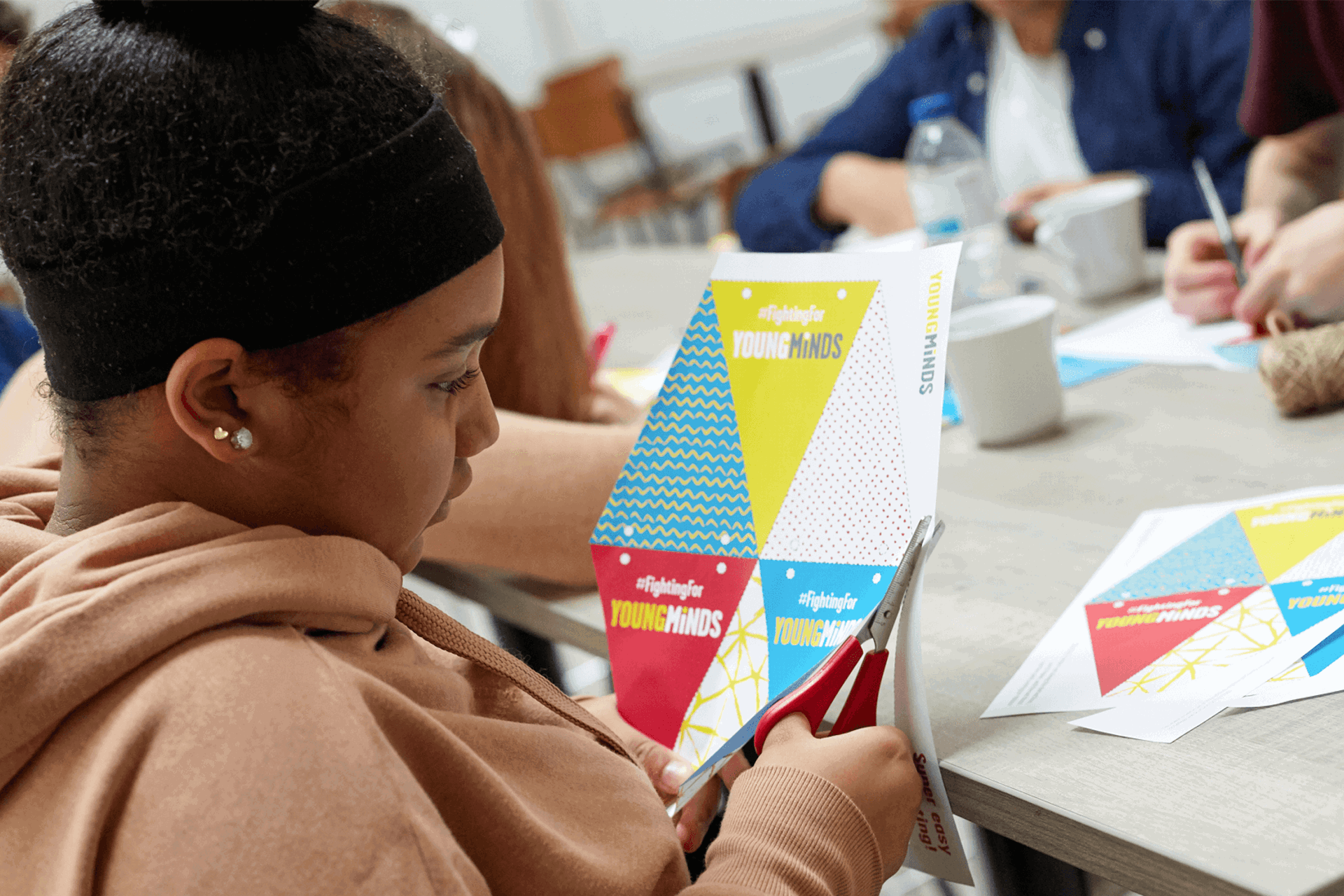 young woman cutting out YoungMinds bunding as fundraising promotional materials