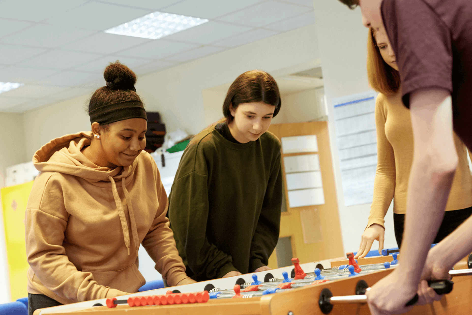 Four young people playing table football.