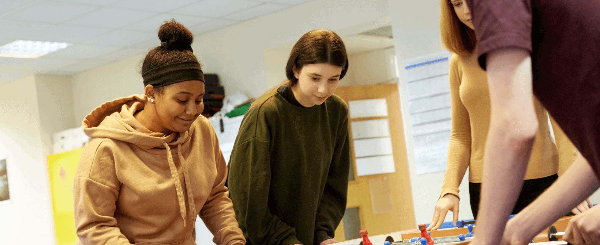 Four young people playing table football.