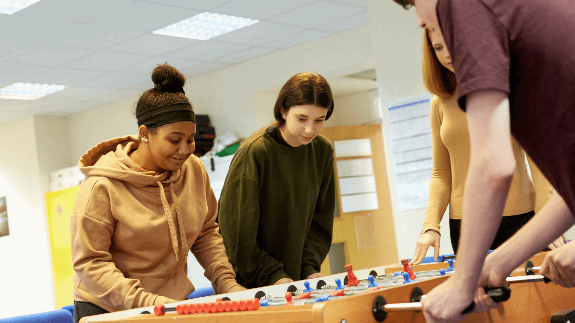 Four young people playing table football.