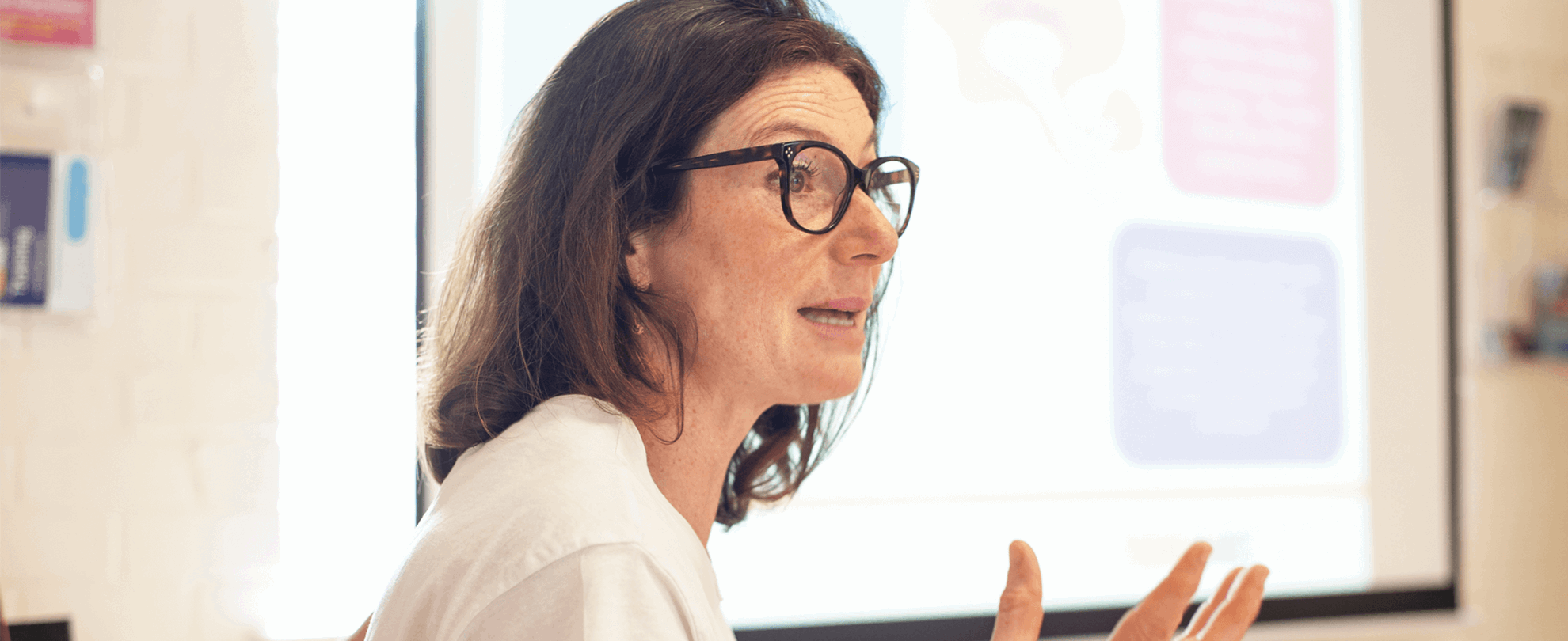 close up of a facilitator wearing eyeglasses talking to parents