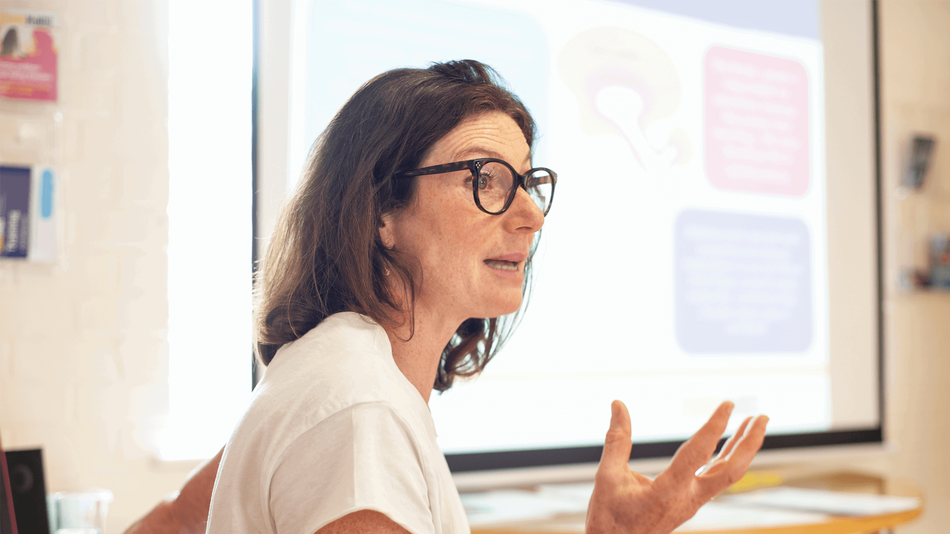 close up of a facilitator wearing eyeglasses talking to parents