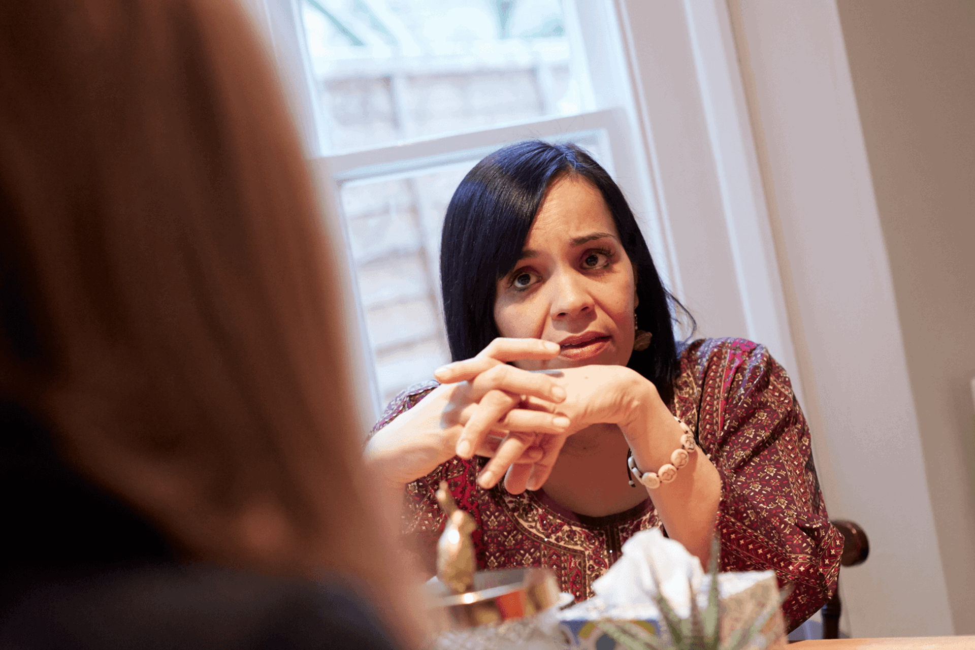 A close up of a lady in conversation at a table