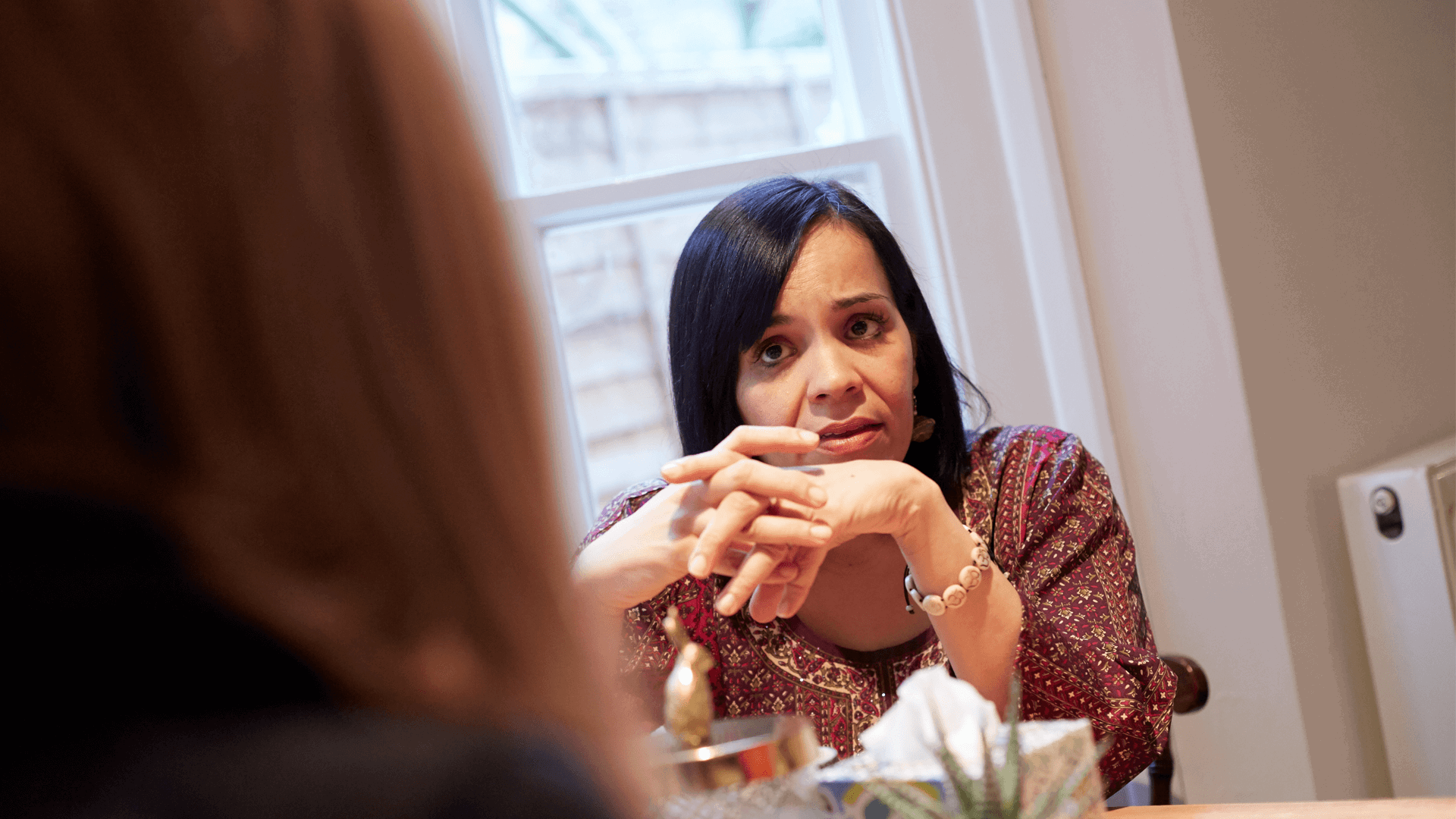 A close up of a lady in conversation at a table