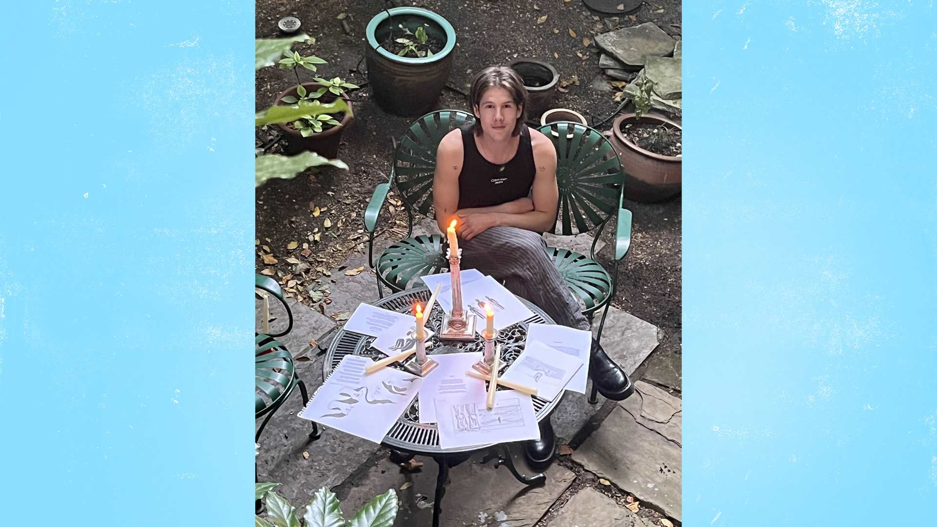 Our fundraiser, Alex D'arbost, sitting at a garden table covered with illustrations for his book.