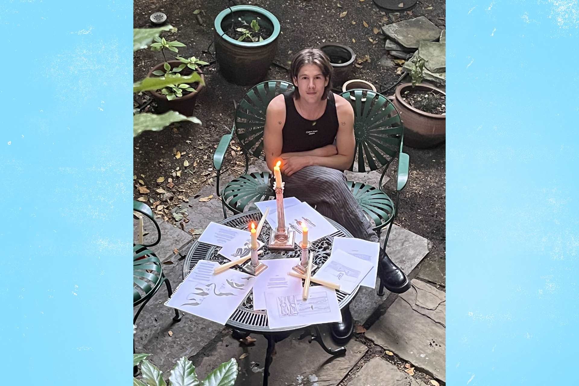 Our fundraiser, Alex D'arbost, sitting at a garden table covered with illustrations for his book.