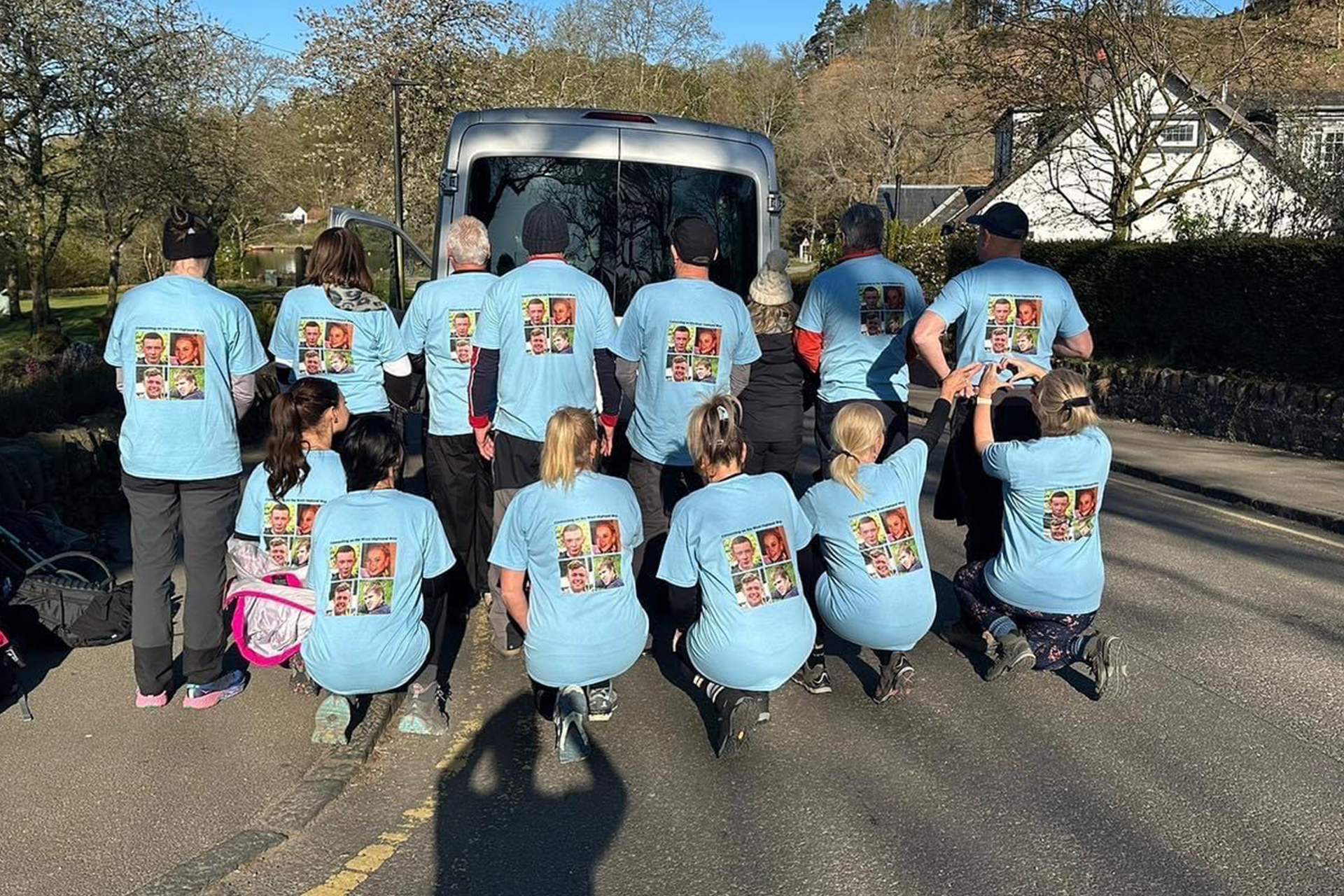 A group picture of 4 Families Walking showing the back of their t-shirts with their loved ones pictures.