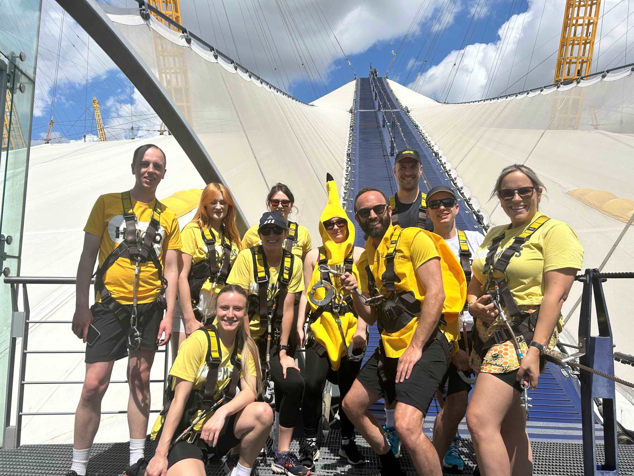 Group of people climbing the O2 building in yellow tshirts