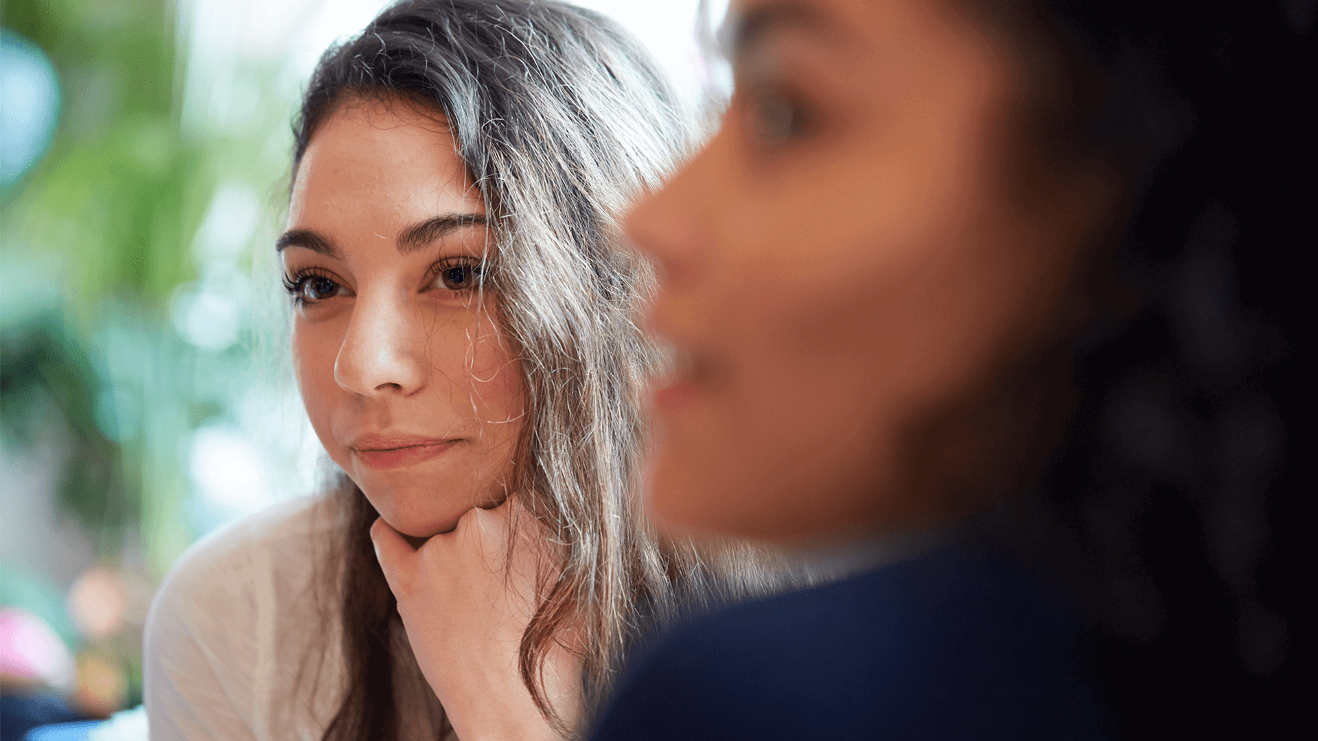 Two young people sitting together and listening to a conversation.