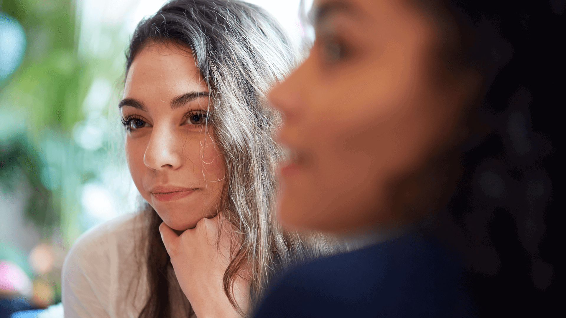 Two young people sitting together and listening to a conversation.