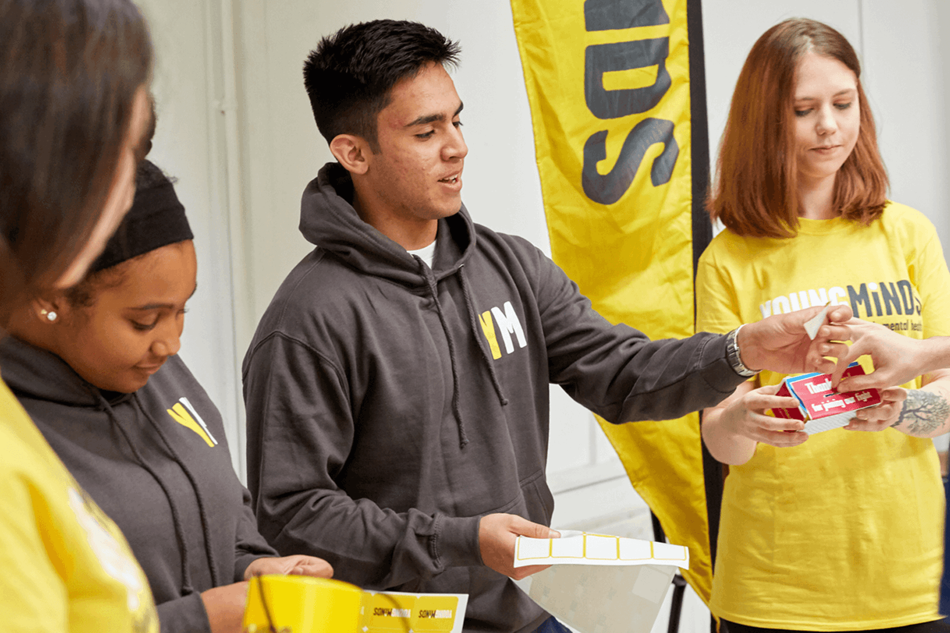 mixed group of YoungMinds volunteer giving out fundraising materials