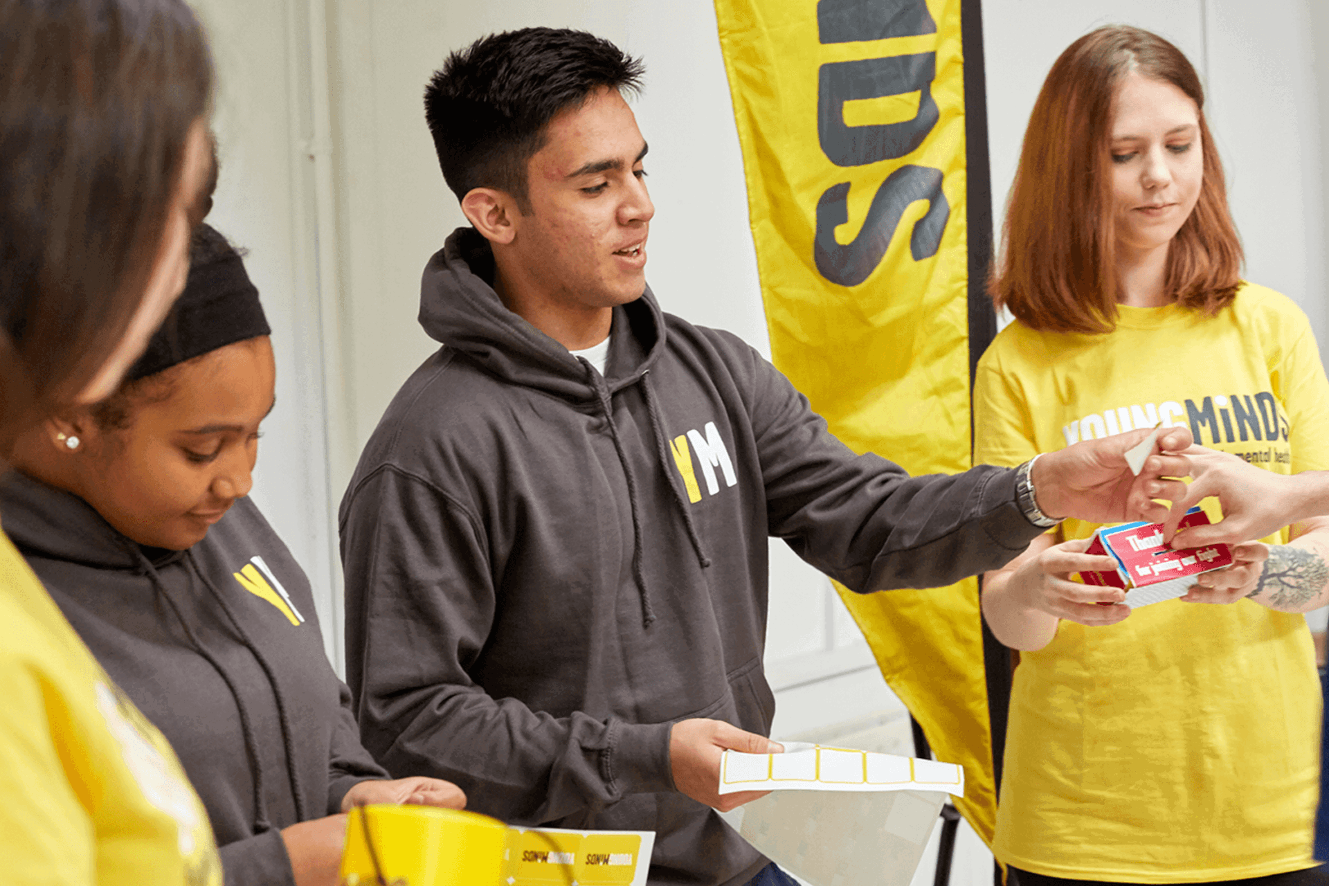 mixed group of YoungMinds volunteer giving out fundraising materials
