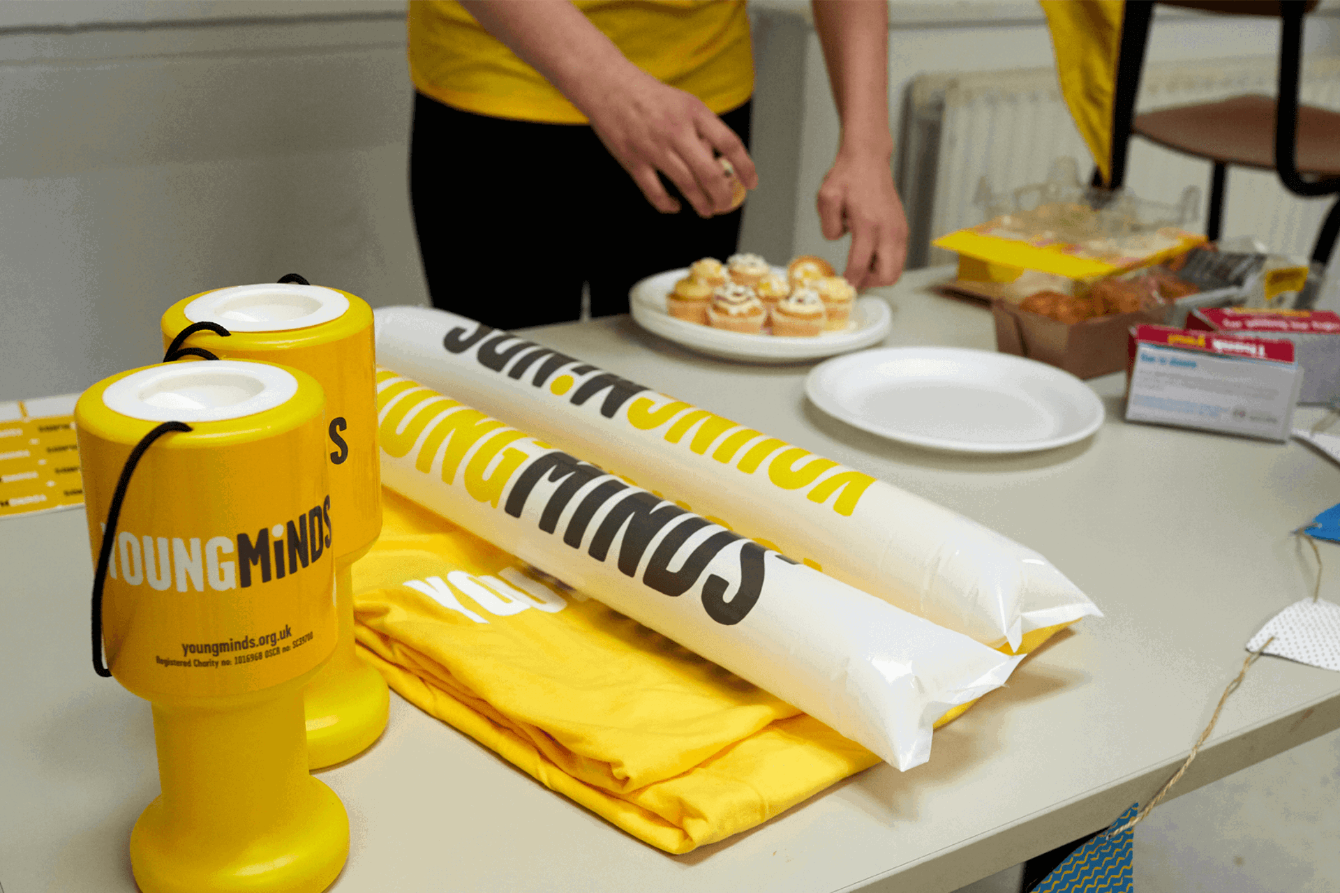 YoungMinds cheering sticks, shirts, stickers, and other fundraising materials on the table