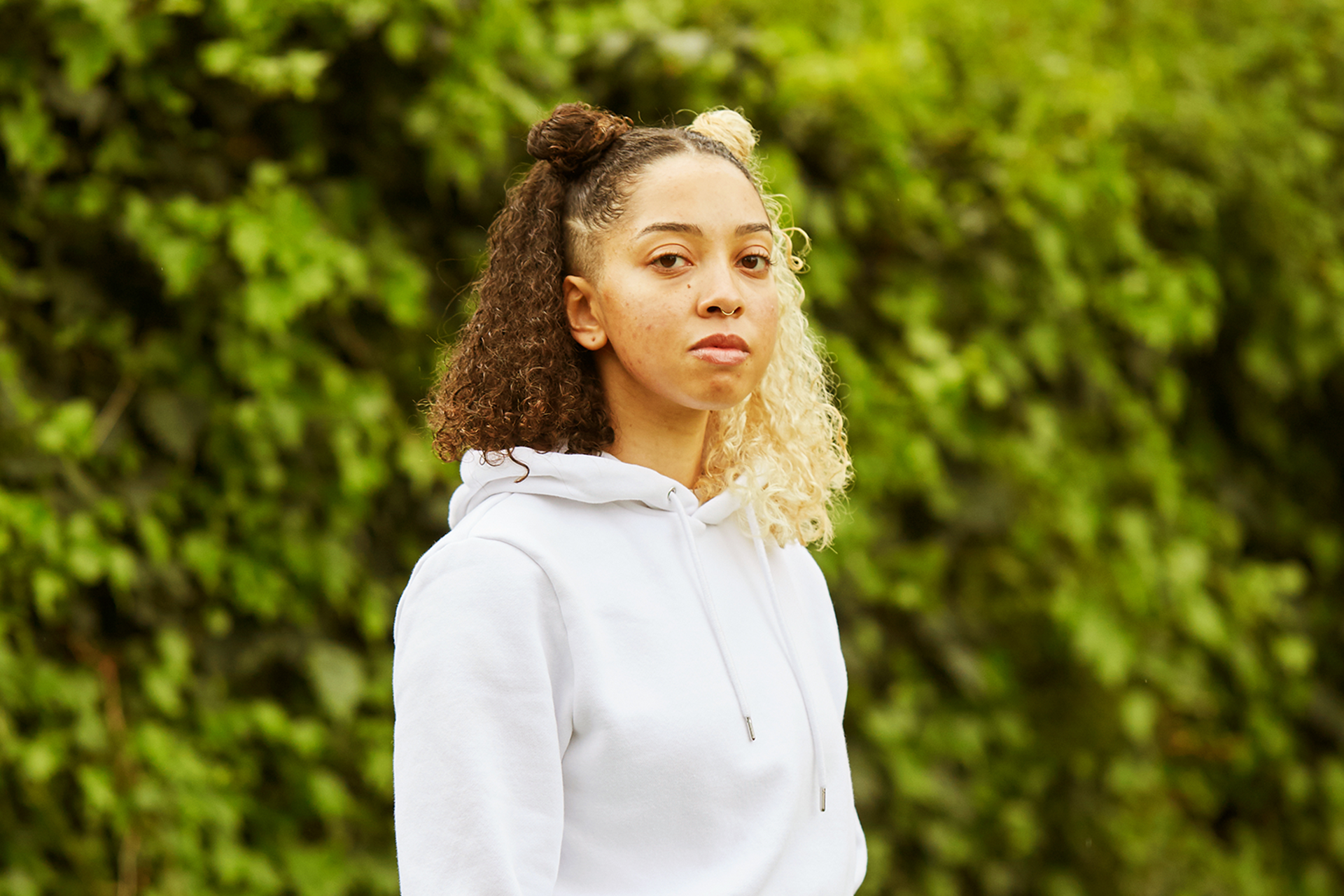 A girl starting at the camera in the park.