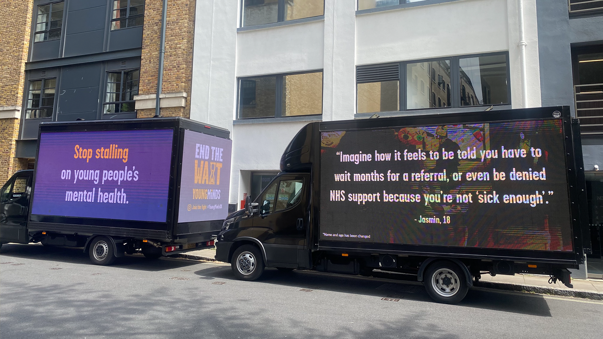Two vans driving around Parliament. The first reads: "Stop stalling on young people's mental health." The second reads "Imagine how it feels to be told you have to wait months for a referral, or even be denied NHS support because you're not 'sick enough' - Jasmin, 18"