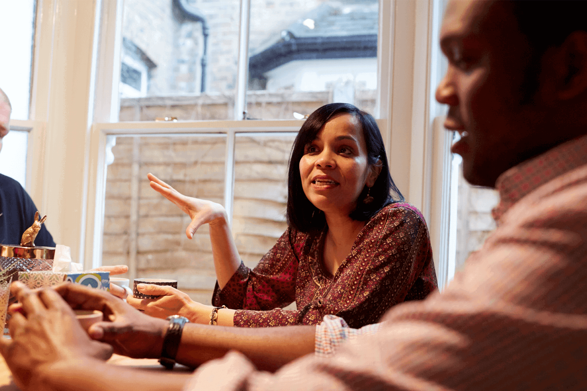 A group conversation at a table with two men and one woman