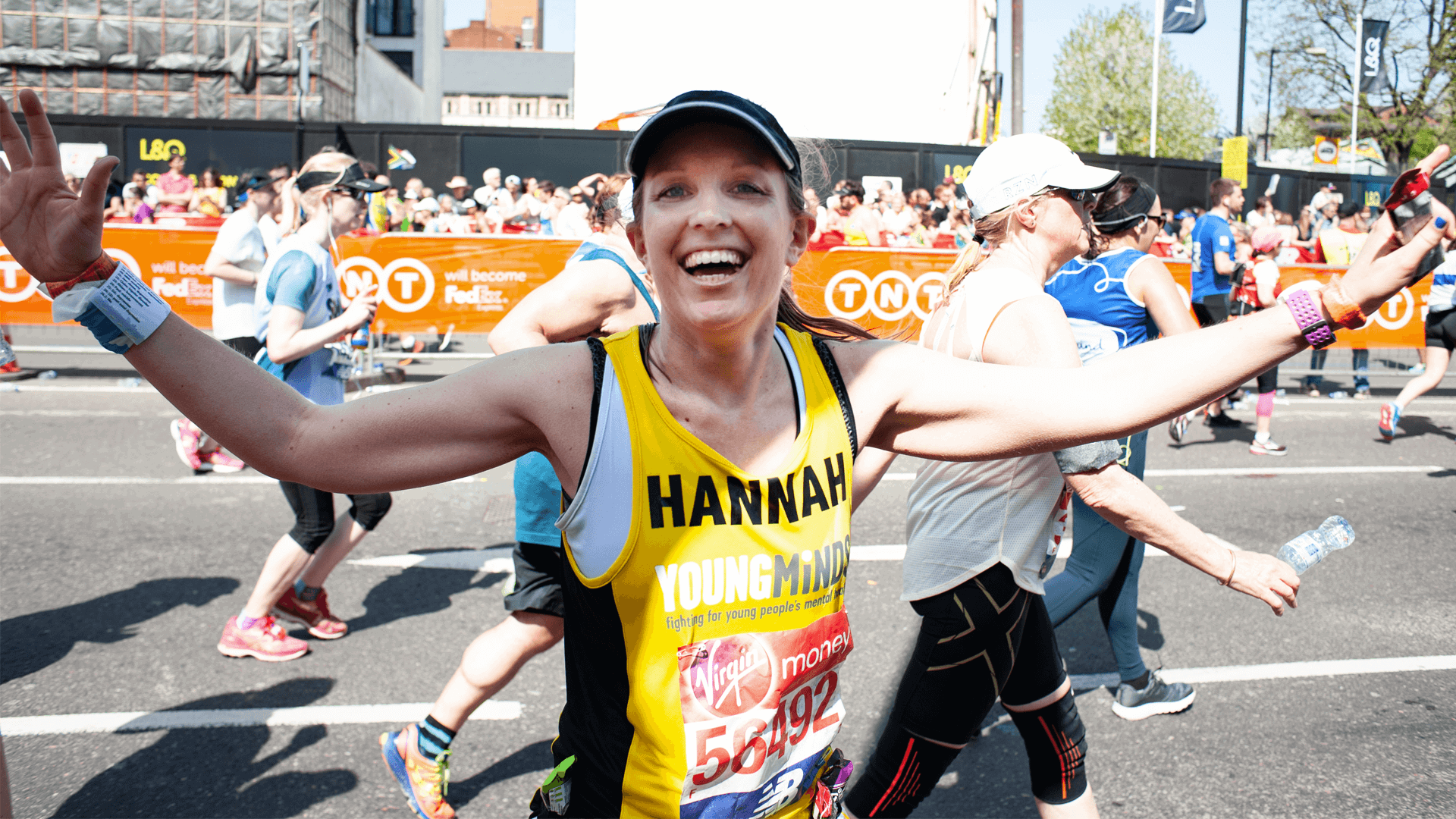 a member of team YoungMinds runner smiles at the camera during the marathon