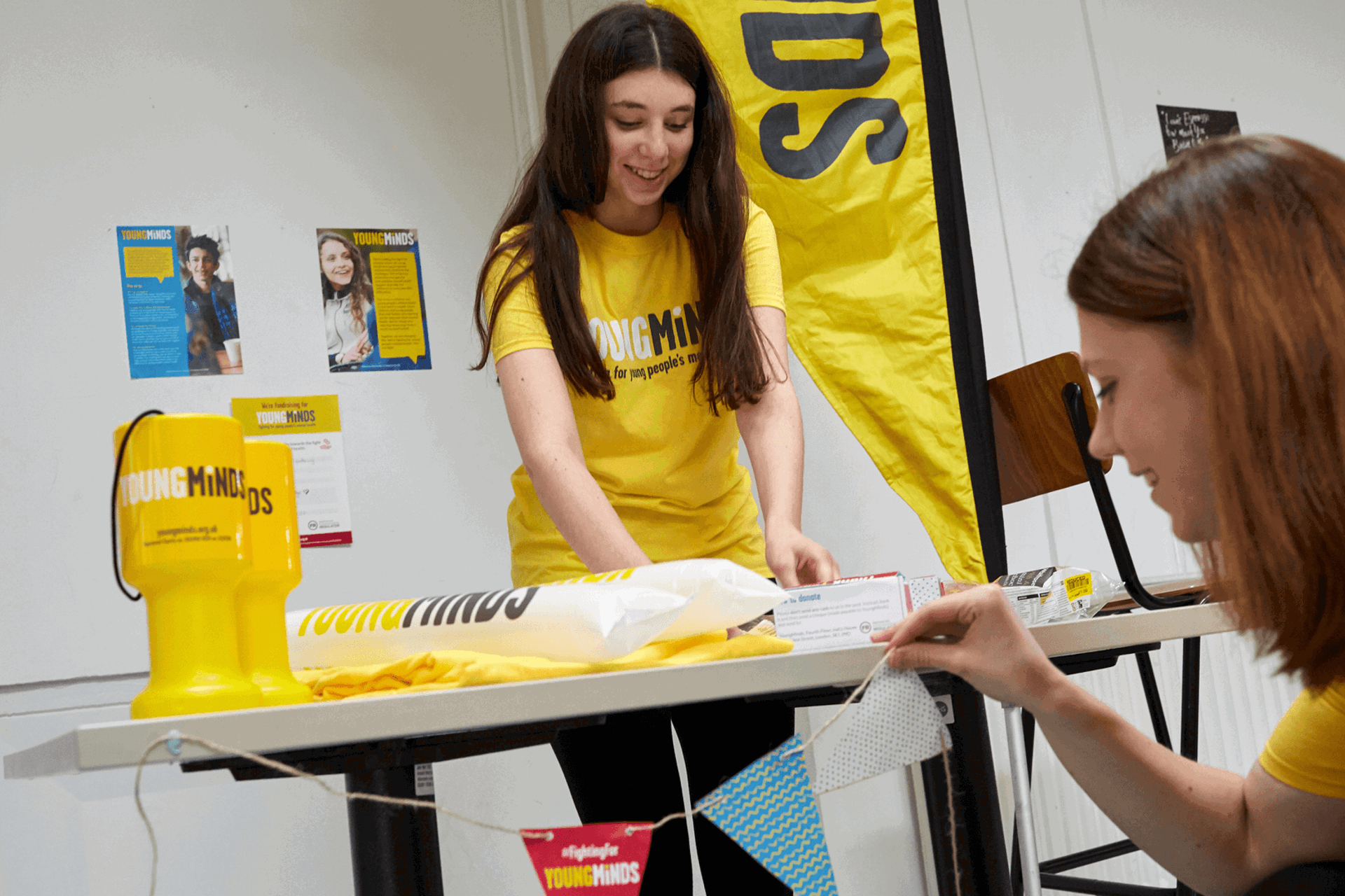two girl volunteers are tidying up YoungMinds fundraising materials