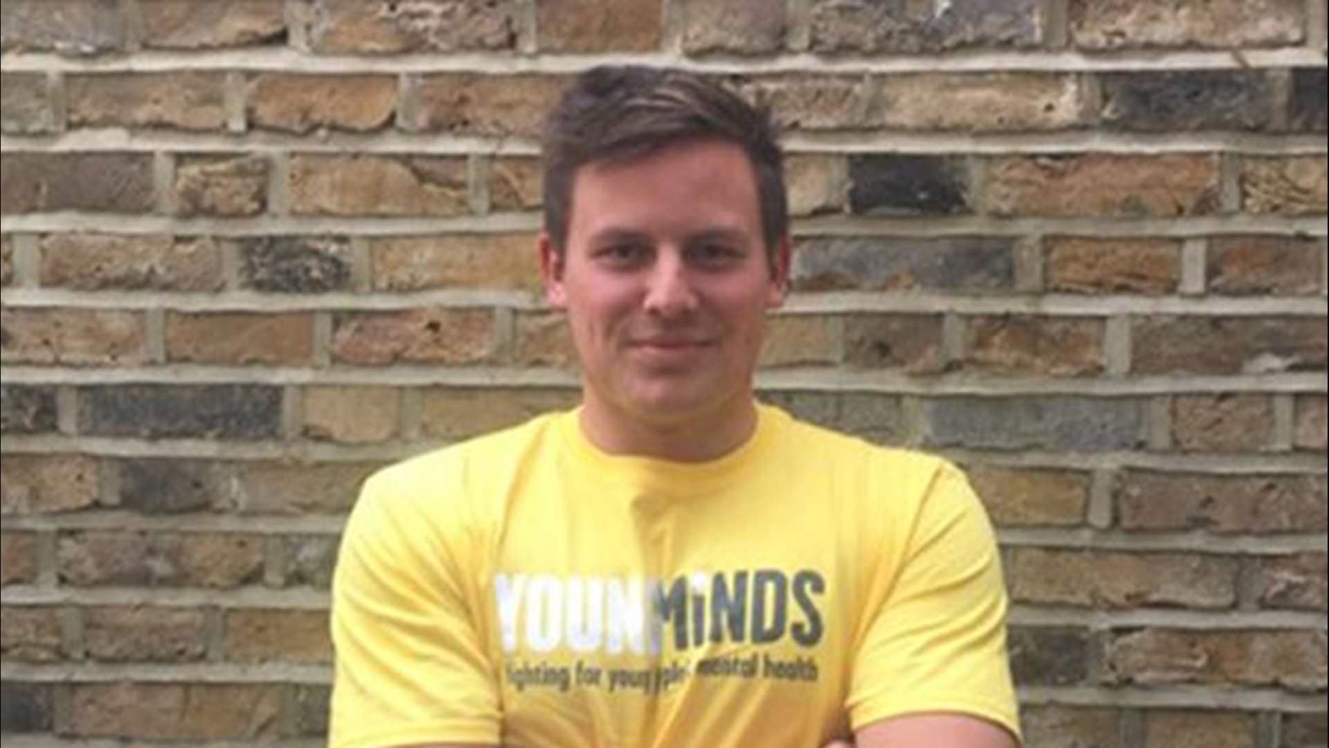 YoungMinds fundraiser Nick Davies with arms crossed standing in front of a brick wall