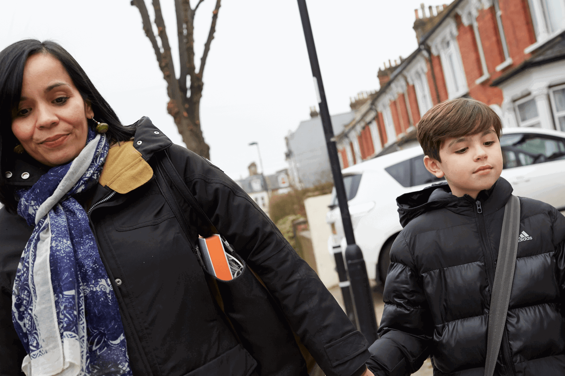 Mother and son walking in the street holding hands