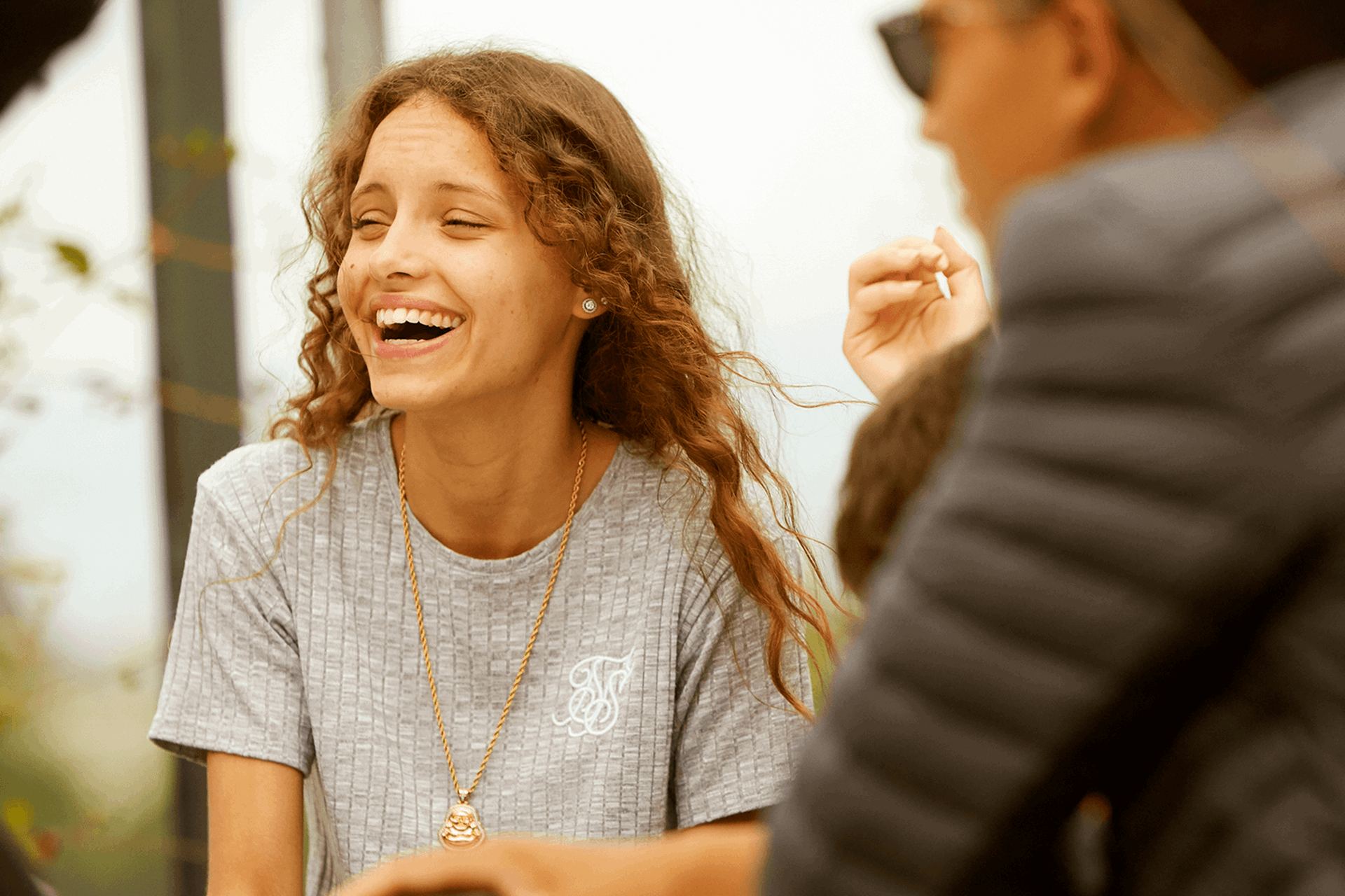 A young person laughing with her friends.