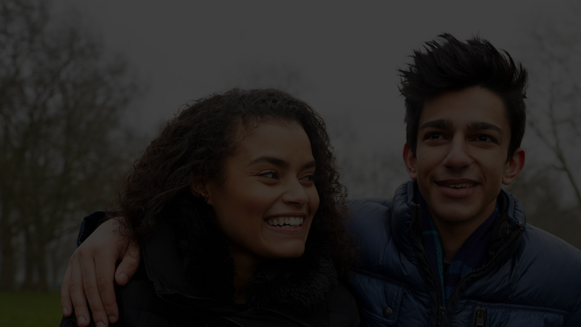 Two young people walking together in the park.