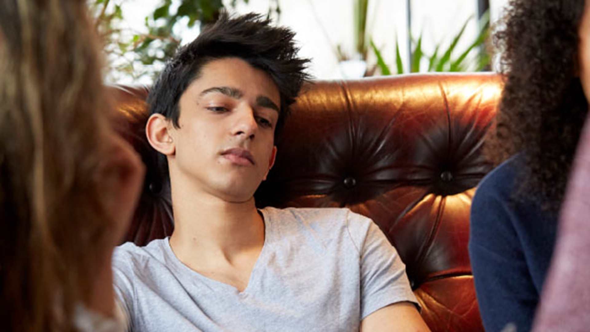 Poster titled ' Struggling with your mental health?' with a photo of a young person on a sofa looking down and not engaging with the other young people in the image.