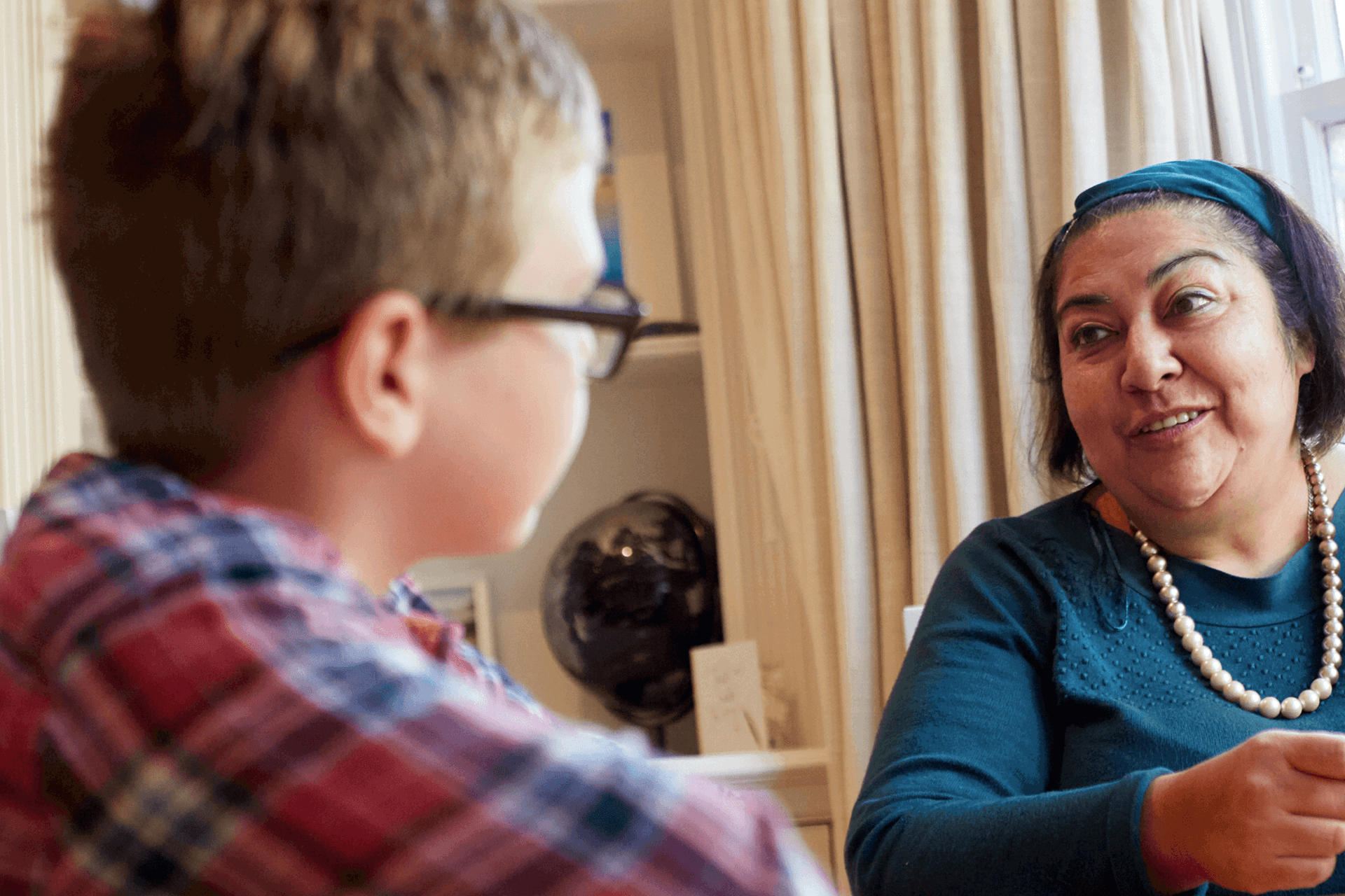 A lady talking to a young boy with a smile on her face