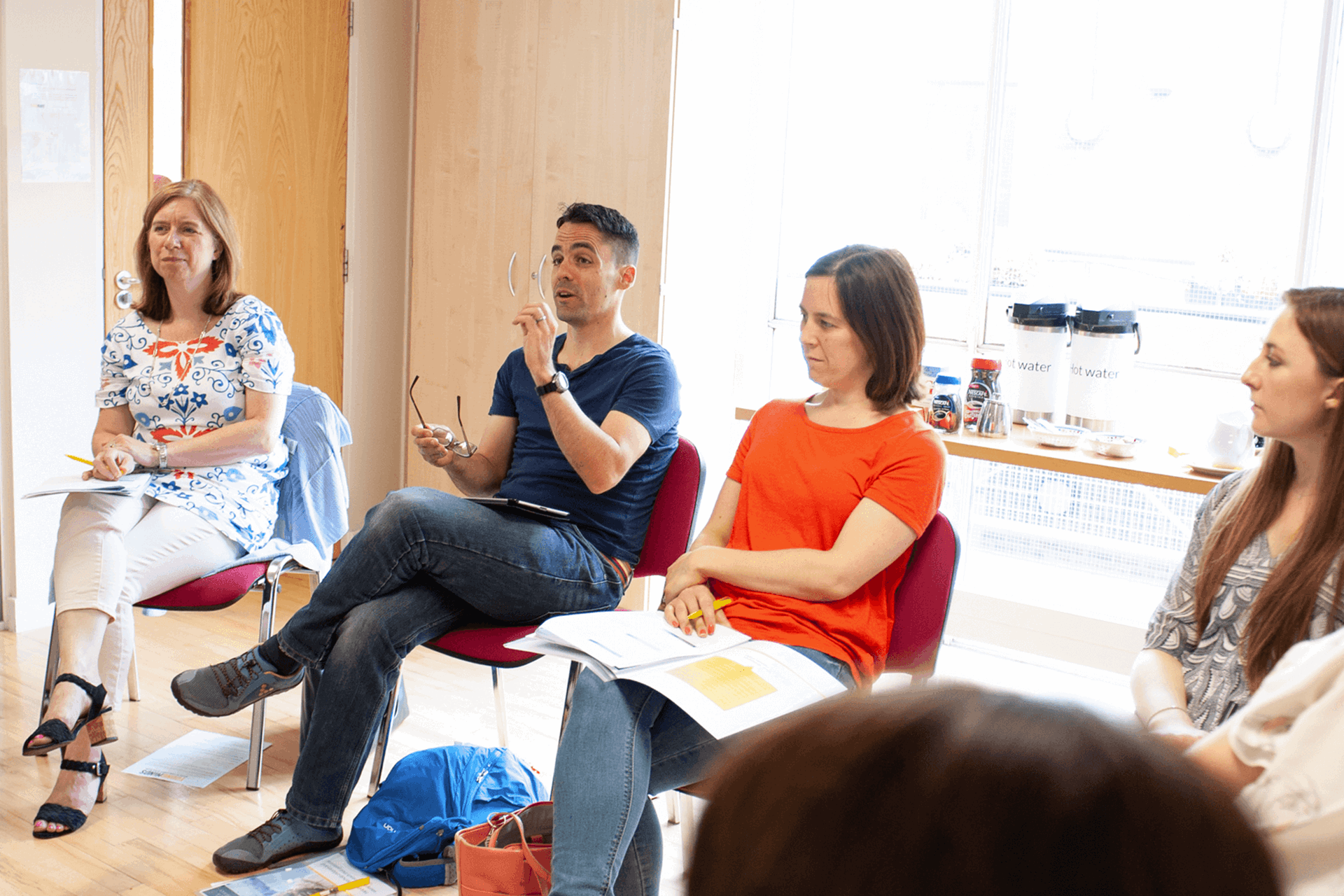 A room full of parents having a discussion in the classroom