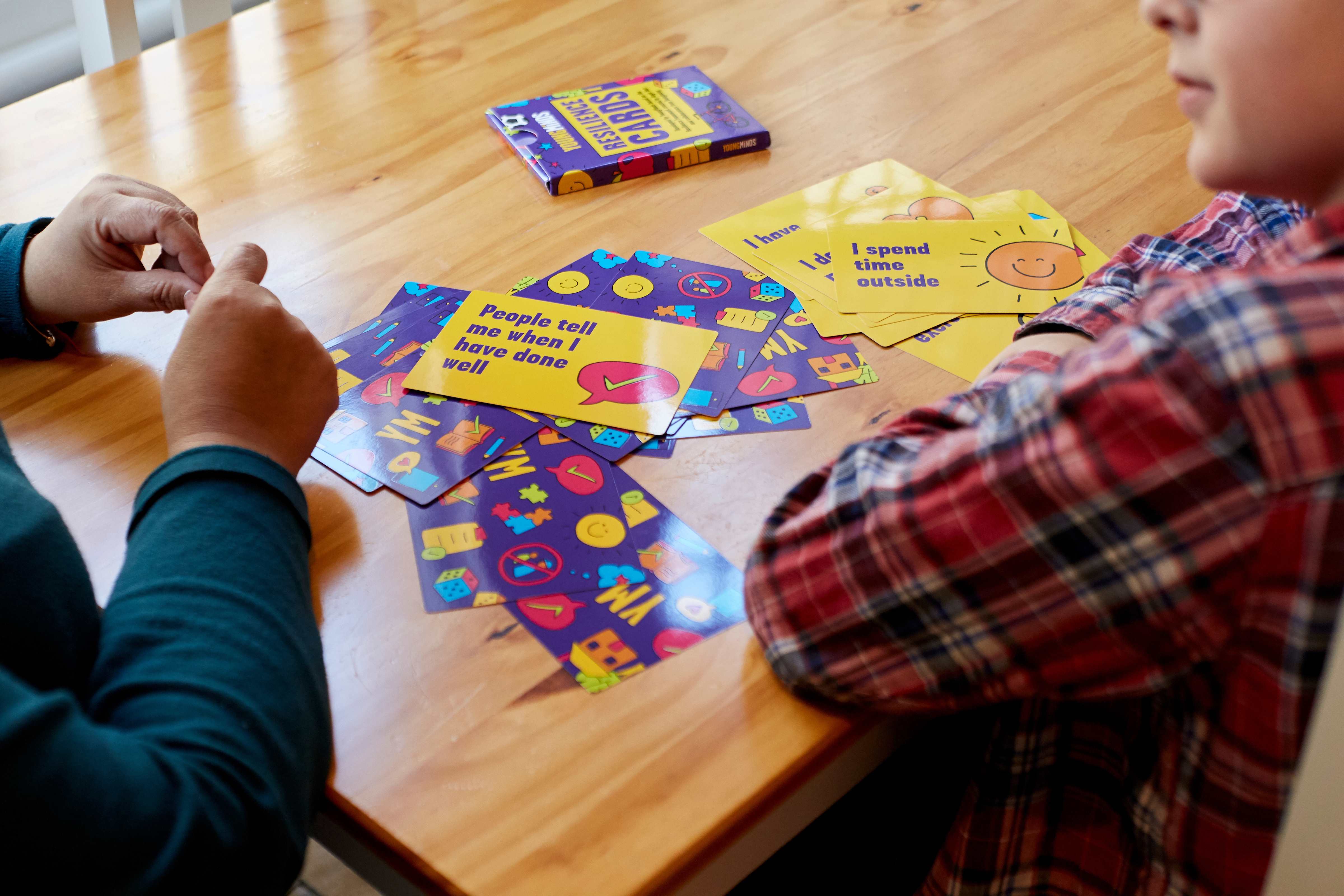 closeup of hands playing YoungMinds resilience cards primary pack