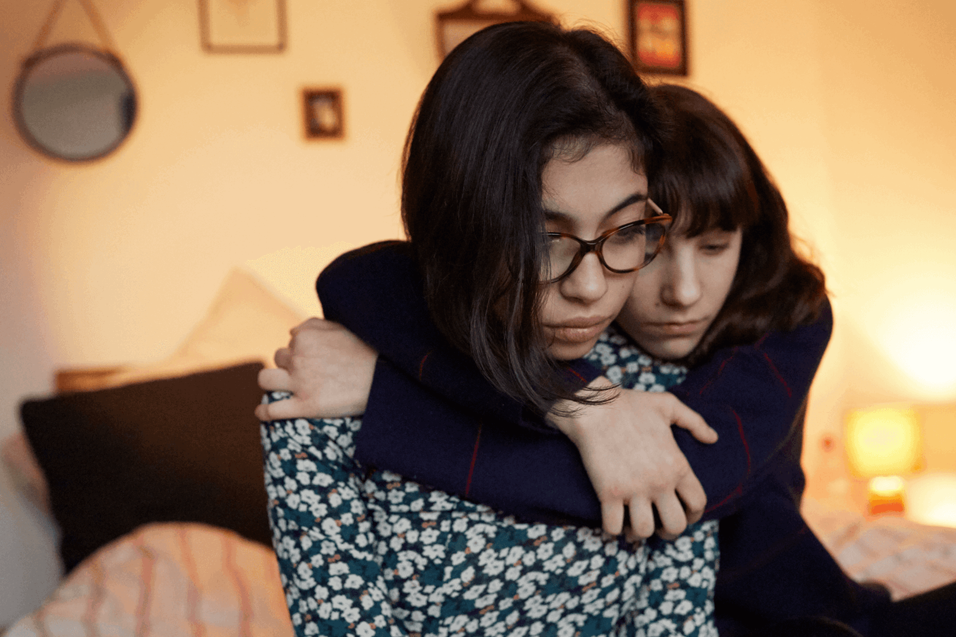 A young person hugging their friend to show support.