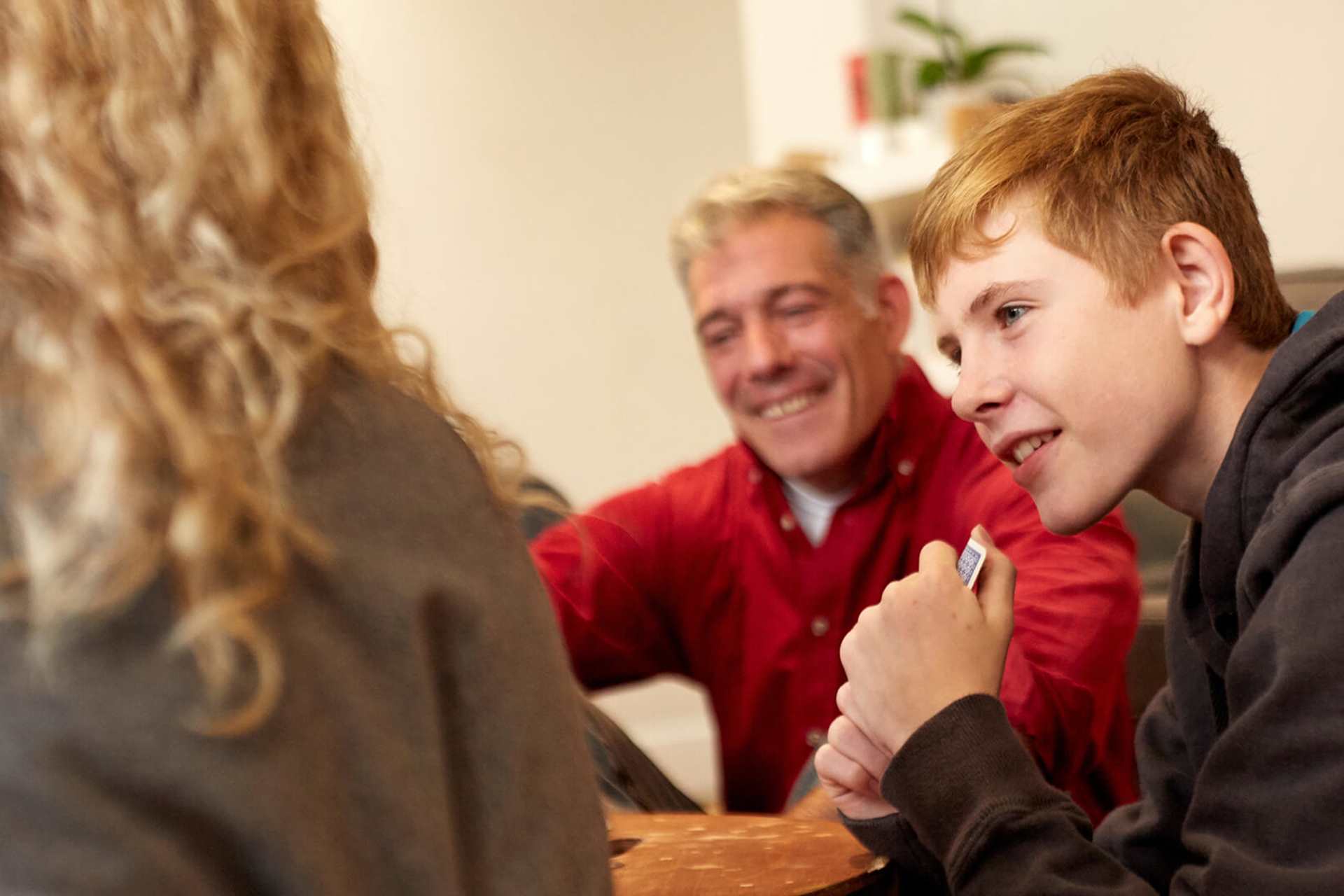 A boy and his parents smiling during a family meeting