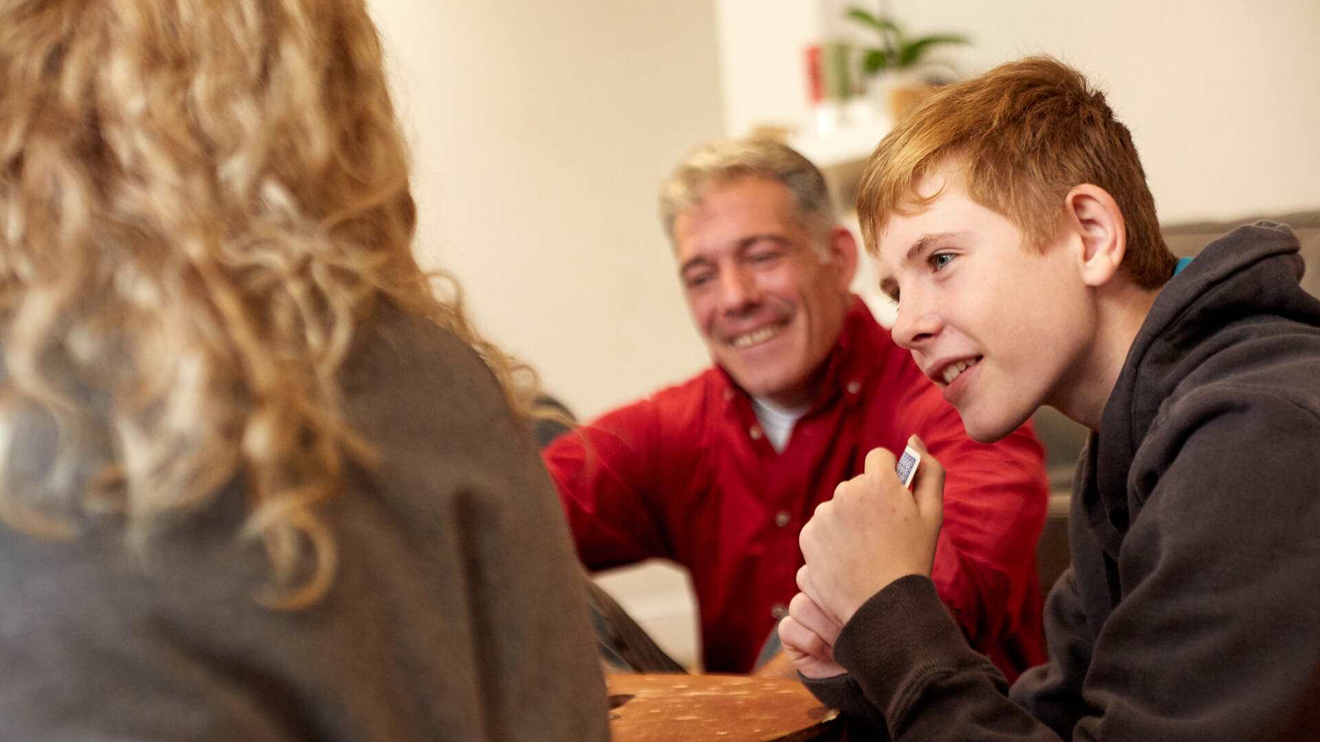 A boy and his parents smiling during a family meeting