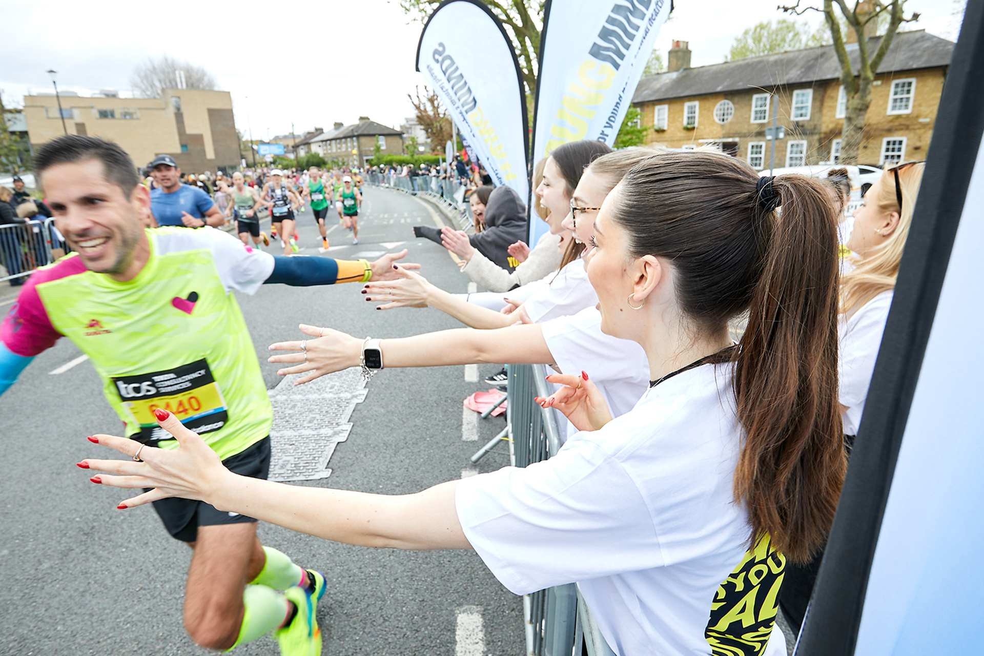 A YoungMinds marathon runner being supported by YoungMinds staff on the side line.