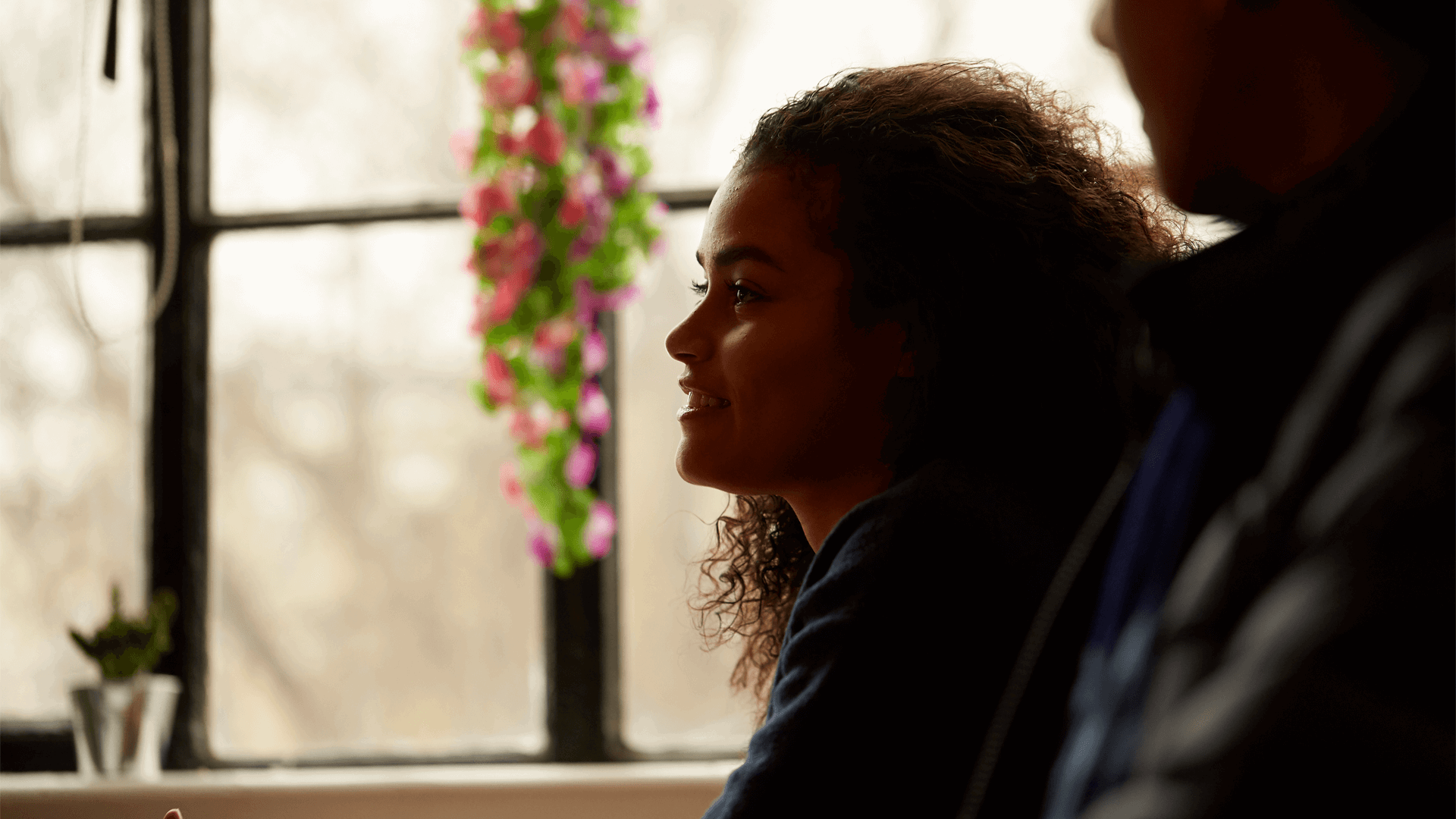 girl-smiling-while-looking-away-with-window-on-background