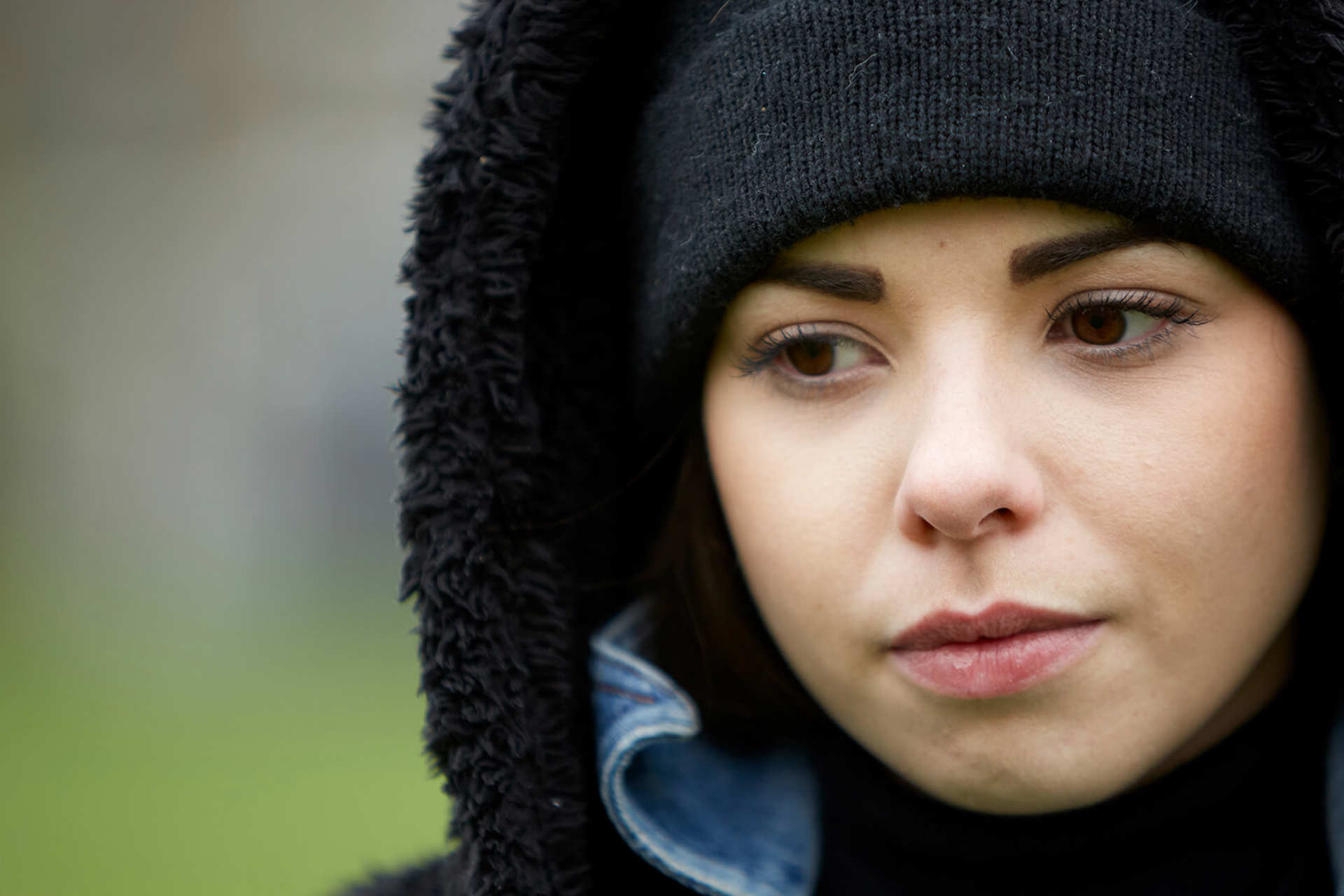 close-up-of-a-girl-wearing-black-beanie-looking-worried-with-eyes-looking-down