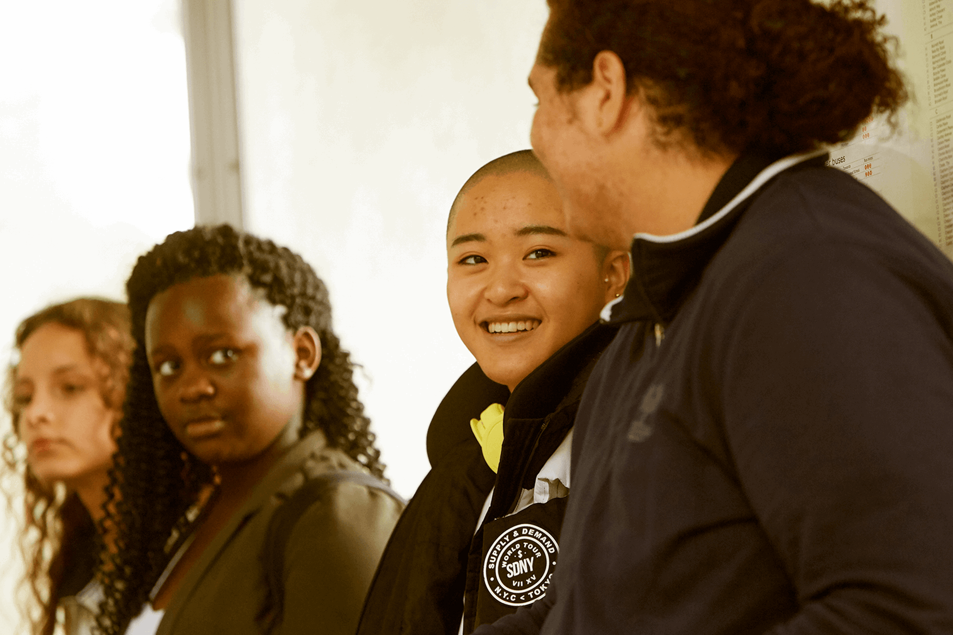 Four young people sitting together in a corridor.