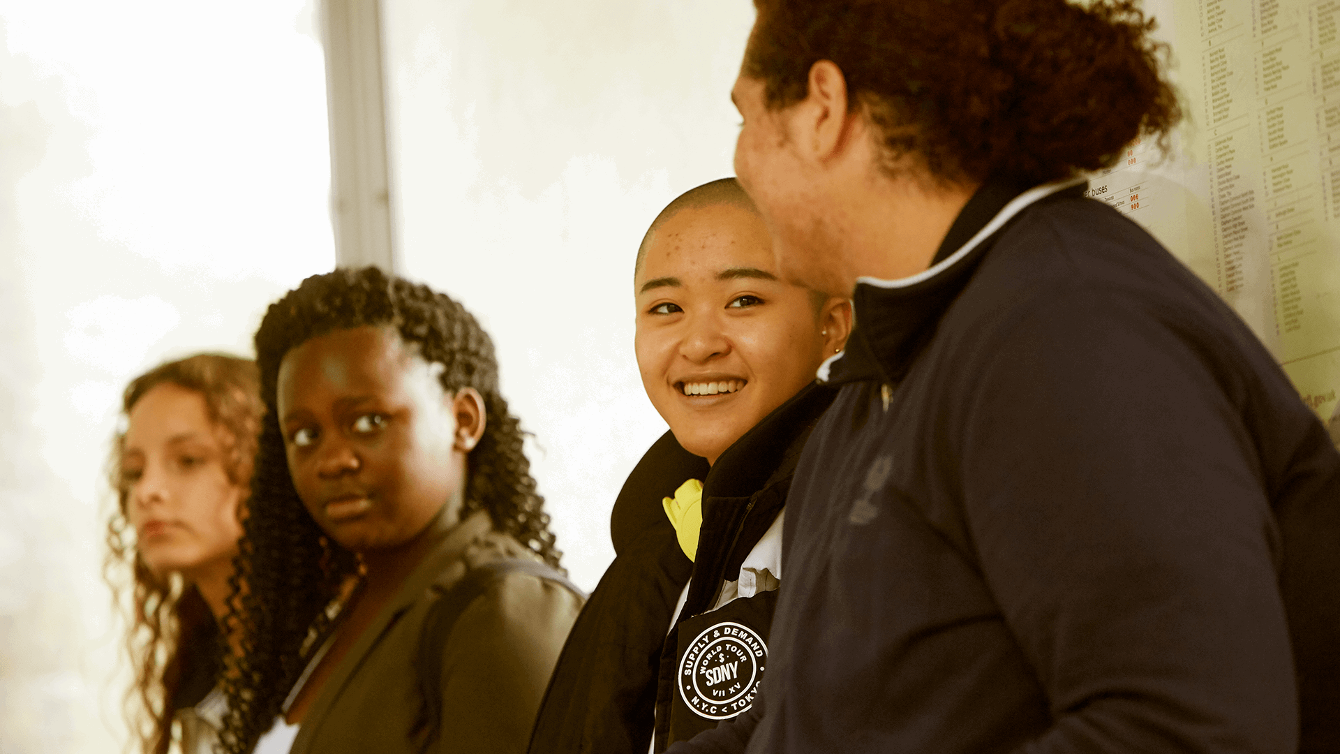 Four young people sitting together in a corridor.