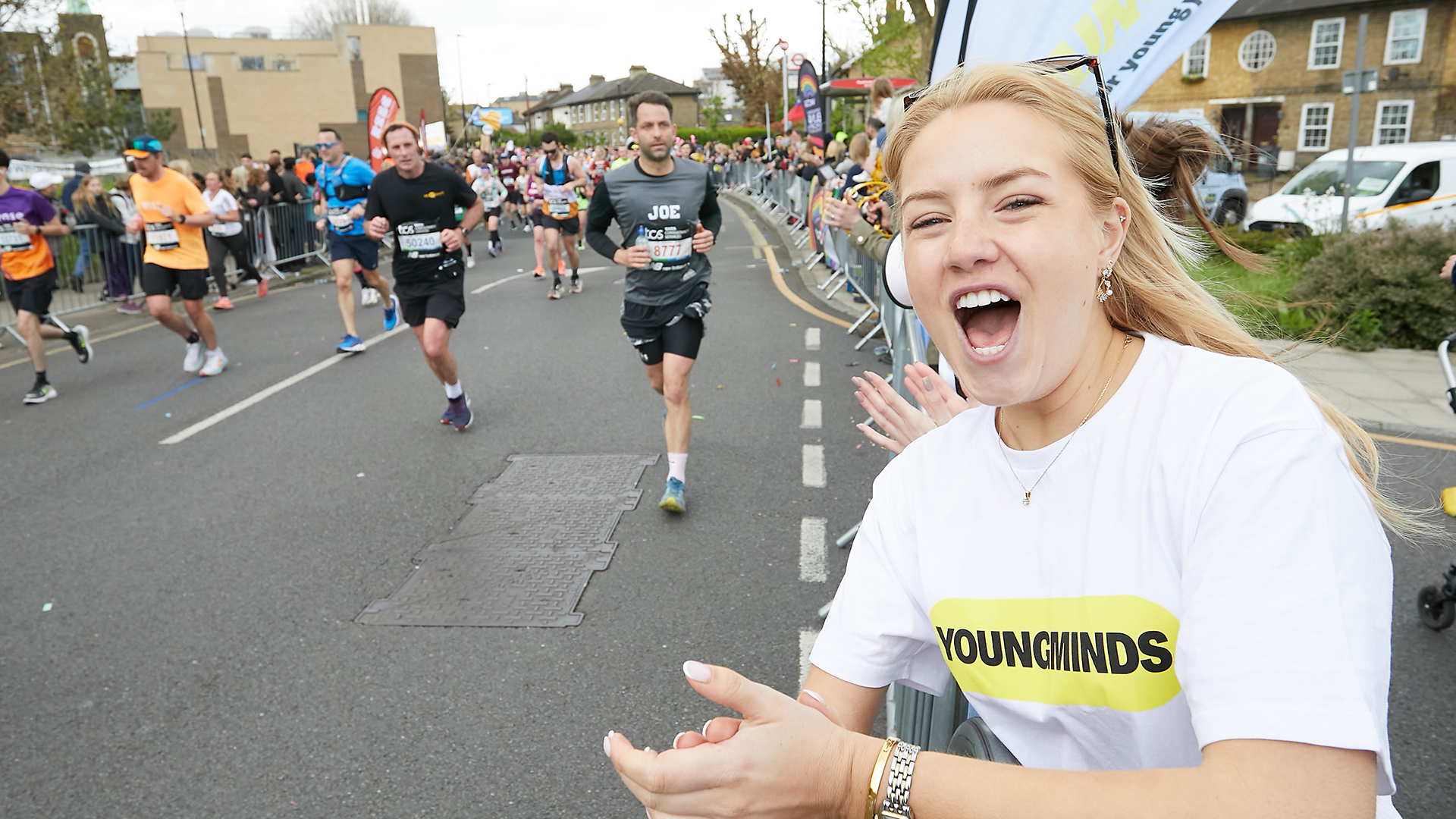 A YoungMinds marathon runner being supported by YoungMinds staff on the side line.
