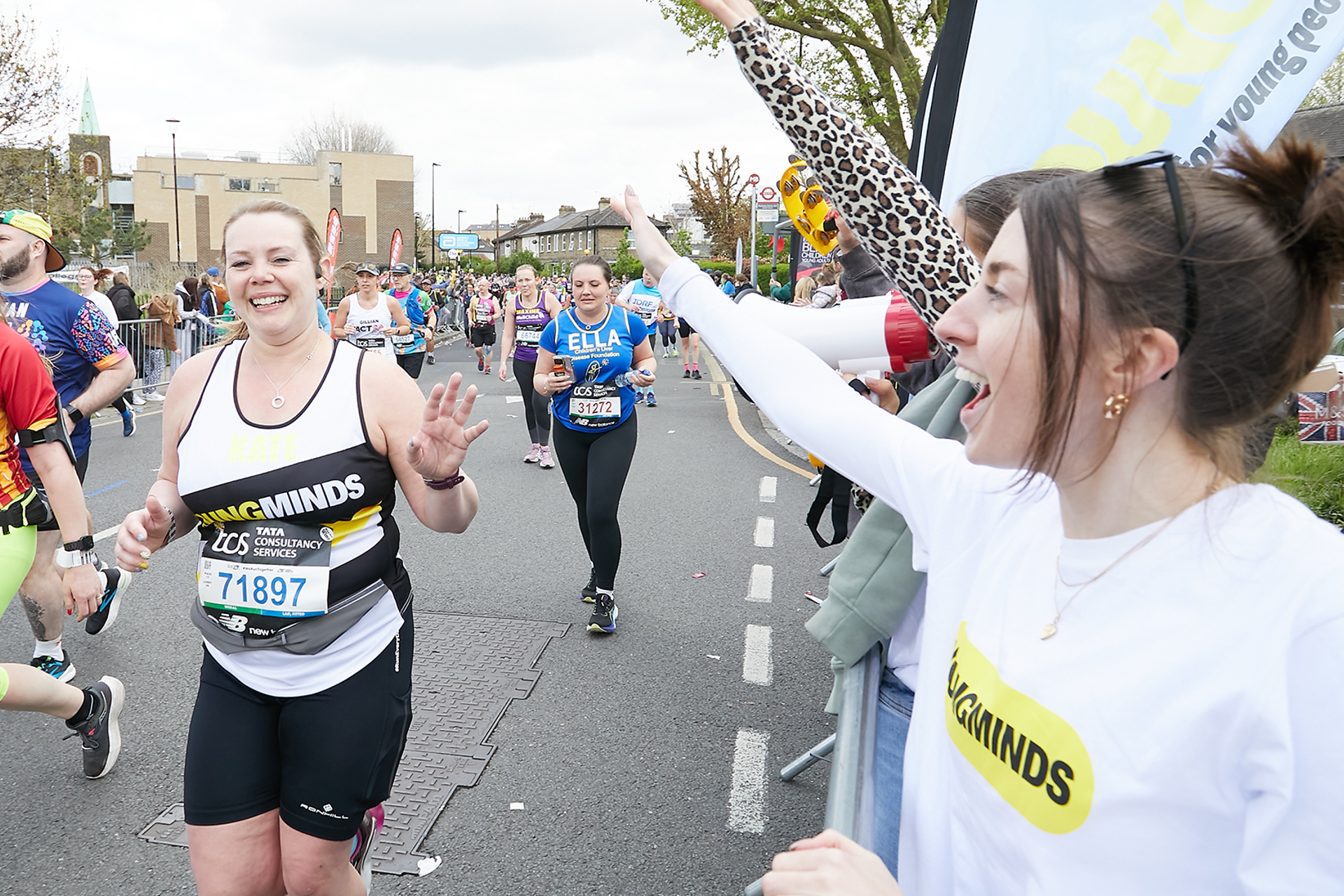 A YoungMinds marathon runner being supported by YoungMinds staff on the side line.