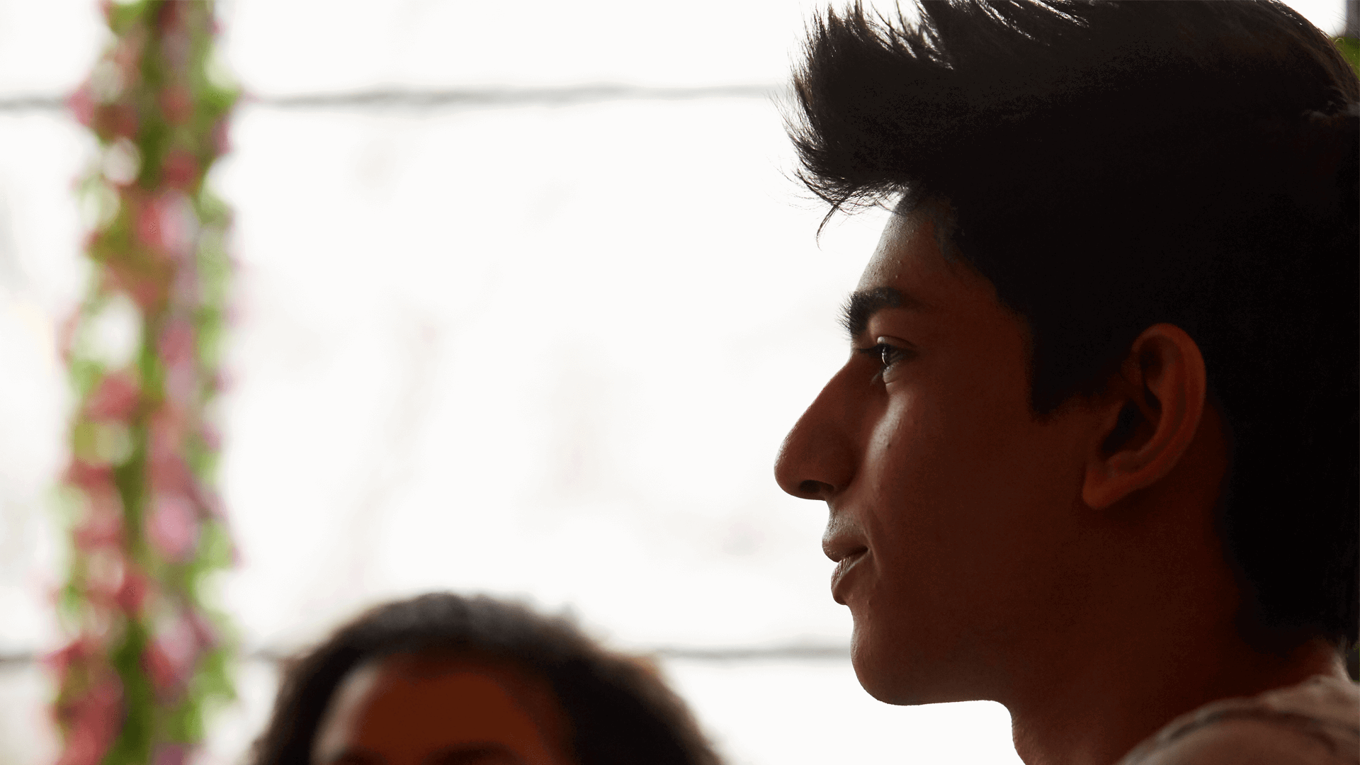 close-up-of-a-boy-looking-away-with-window-on-background