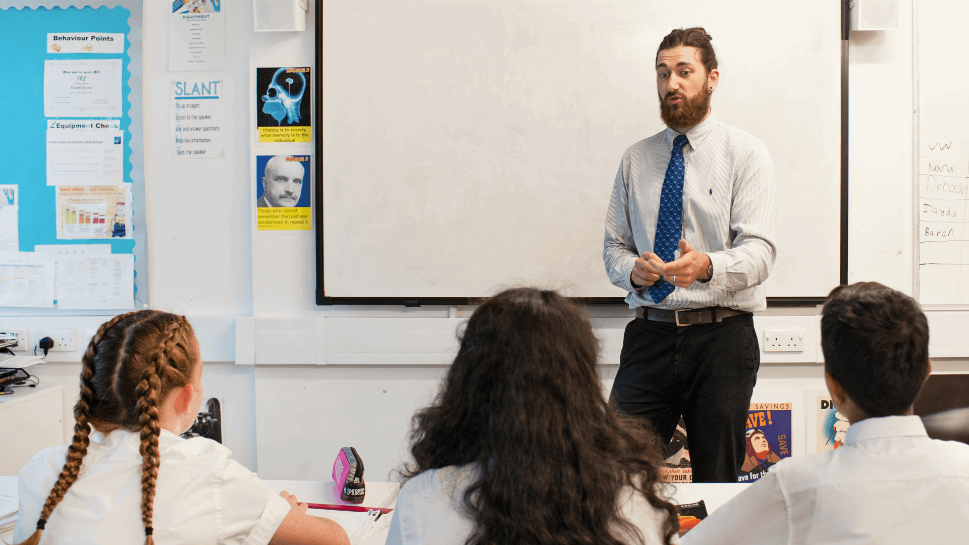 A male teacher leading a class room of students