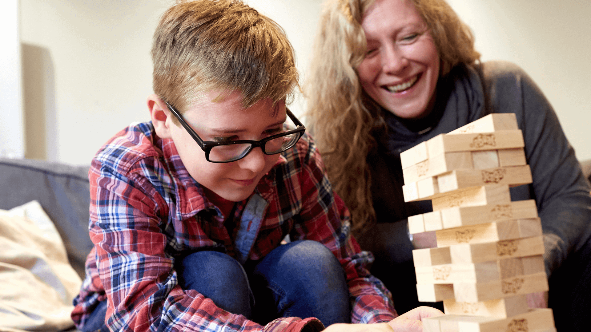 Mother and son playing jenga together having a lot of fun 