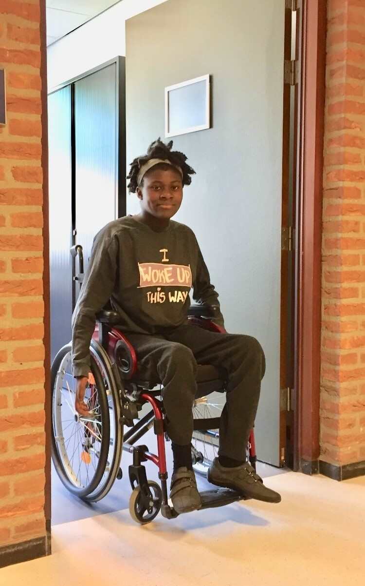 Simi in her wheelchair wearing a top that says, 'I woke up this way'.